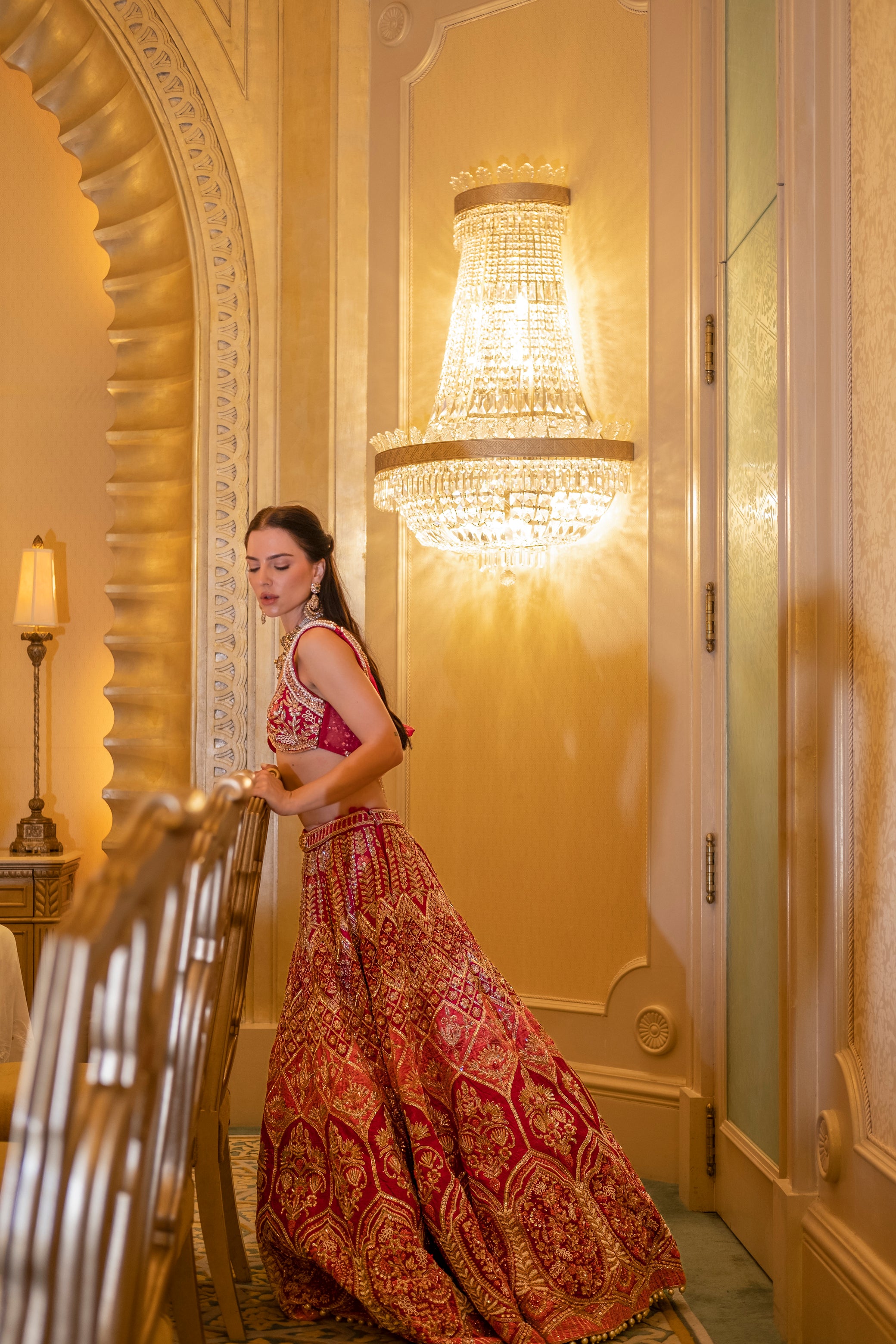 Luxurious pink lehenga with velvet accents and intricate handwork, featuring a cowl-neck blouse and delicate net dupatta