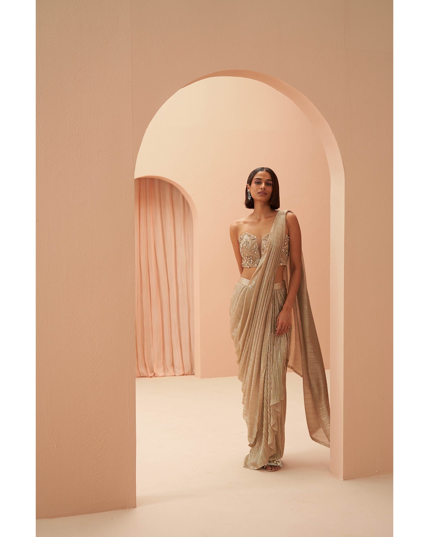 Gilded Grace: Hand-embroidered enchantment graces this golden drape saree, a radiant masterpiece of timeless elegance.
