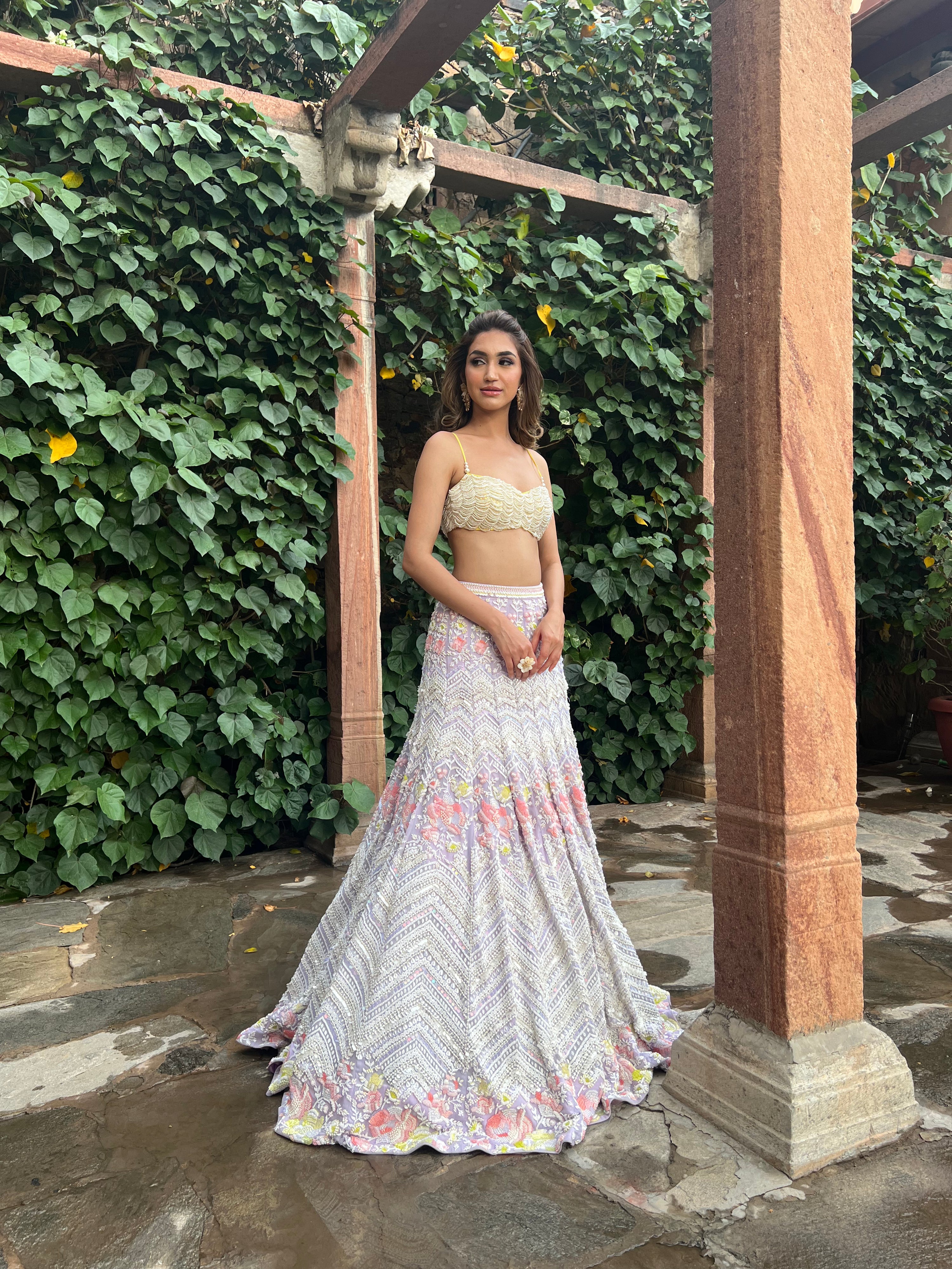 Luxurious bridal look with The Alara Mermaid Lehenga, featuring a crystal tassel choli and a metallic georgette skirt with delicate chevron and floral details