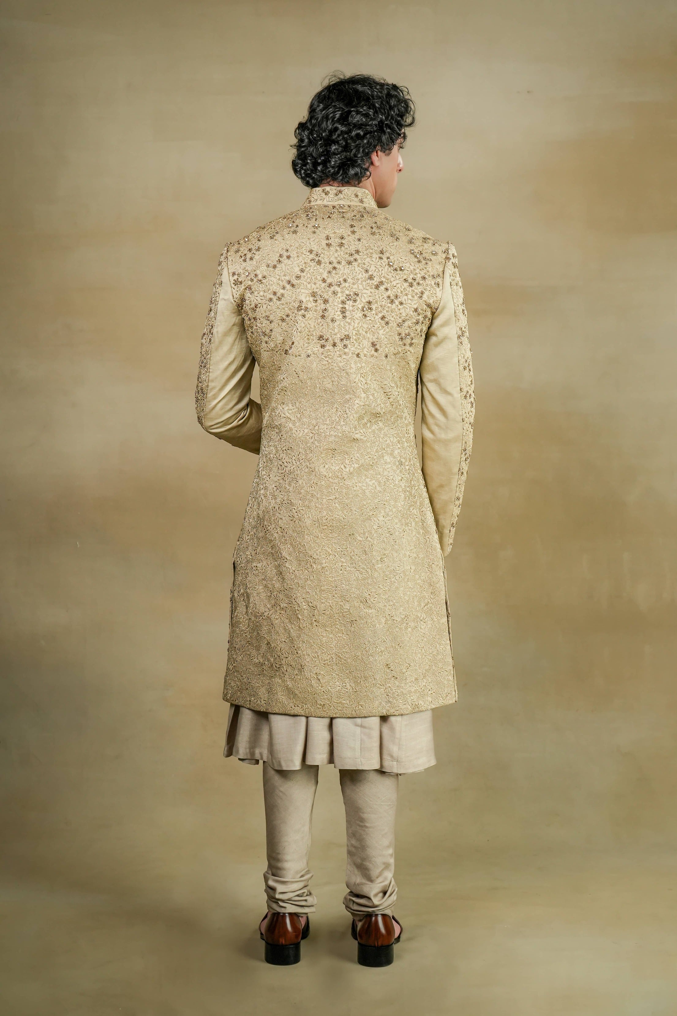 Back view of the Sandune Sherwani, showcasing detailed embroidery and a tailored fit.Full view of the Sandune Sherwani on a mannequin, emphasizing its sophisticated silhouette