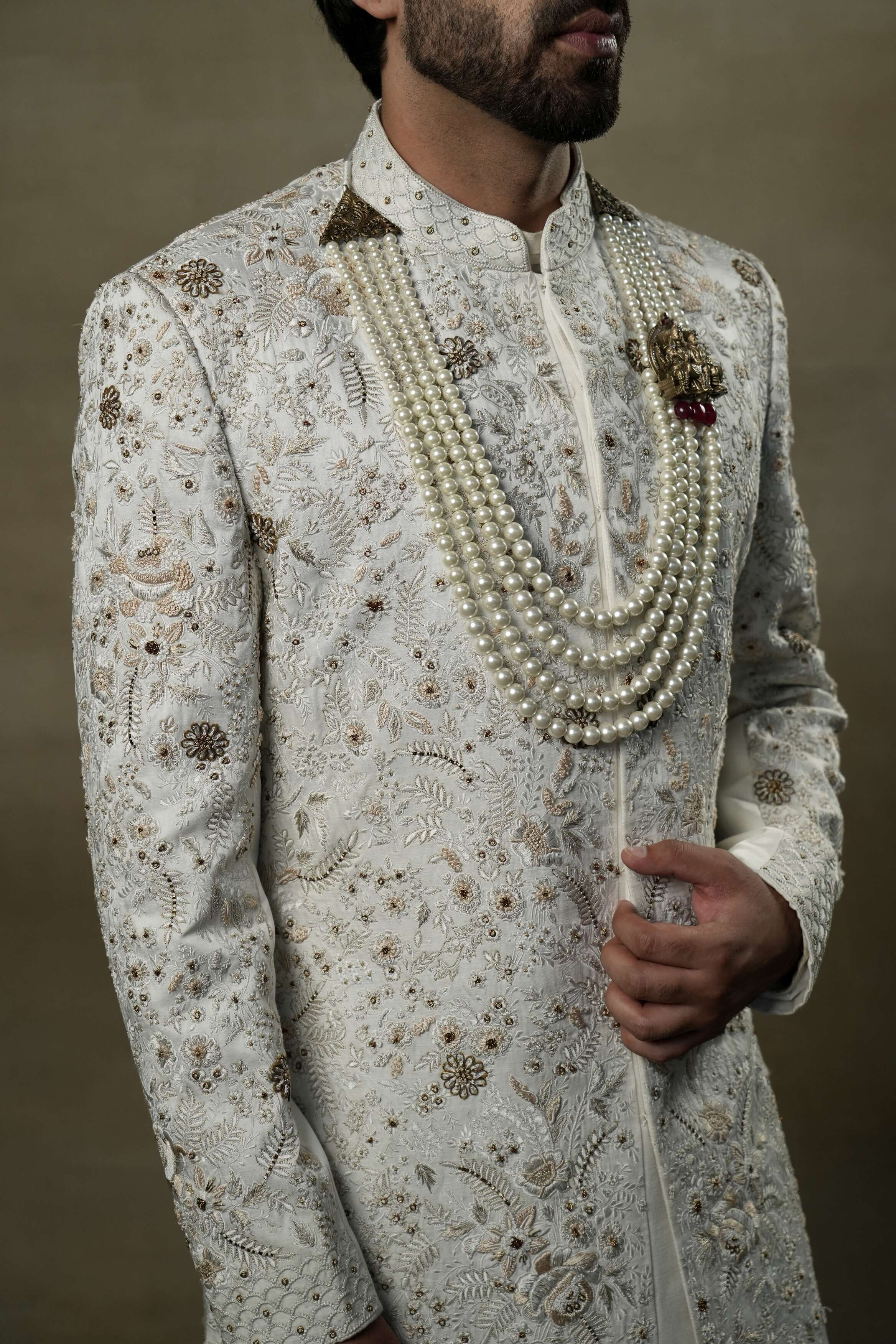 Close-up of the Ivory & Gold Sherwani, revealing intricate gold embroidery and fine detailing.