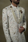Close-up of the Ivory & Gold Sherwani, revealing intricate gold embroidery and fine detailing.