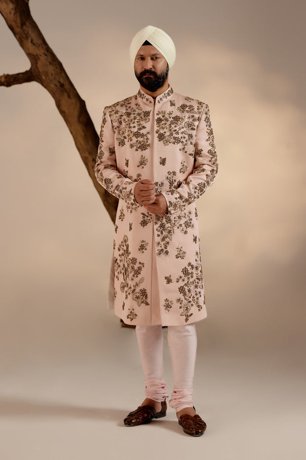 Model showcasing the Frosted Almond Sherwani, exuding timeless charm with its delicate hue.Close-up of the Frosted Almond Sherwani, revealing intricate embroidery and exquisite detailing