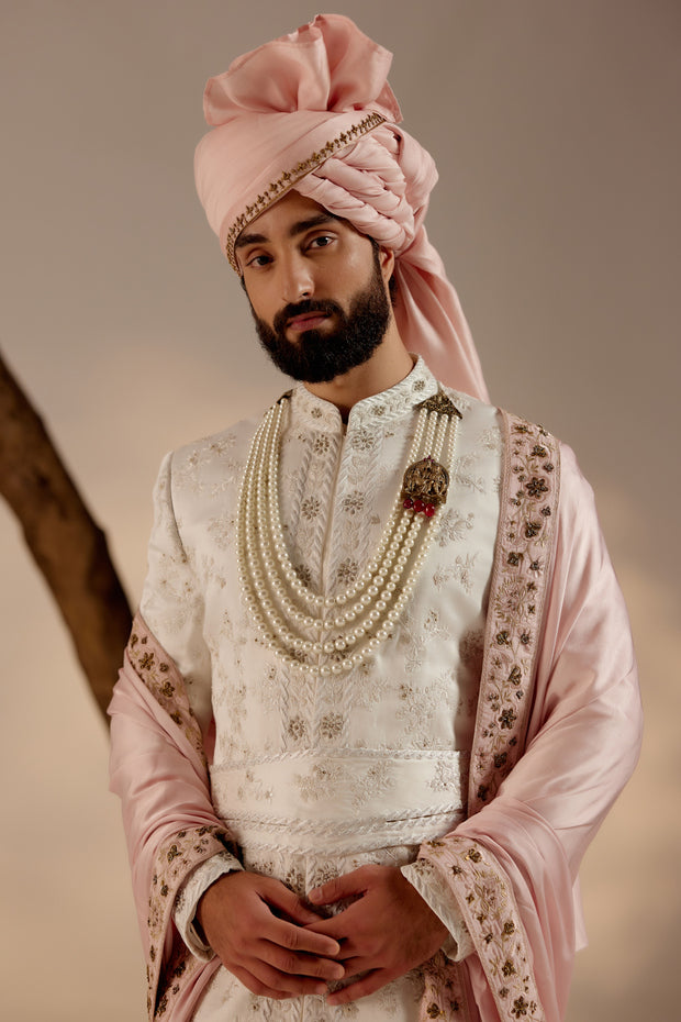 Introducing our exquisite white all-over hand-embroidered sherwani set, a true masterpiece of craftsmanship and elegance.