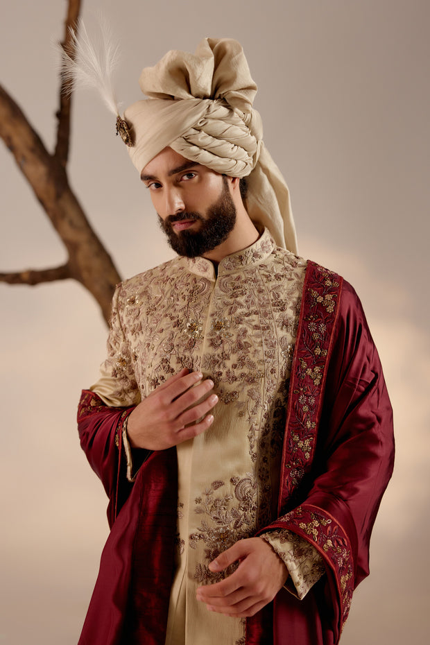 Introducing our masterpiece: the sand grey sherwani, intricately hand-embroidered with resham, silver threads, dabka, and zari, creating a captivating tapestry of textures and designs.