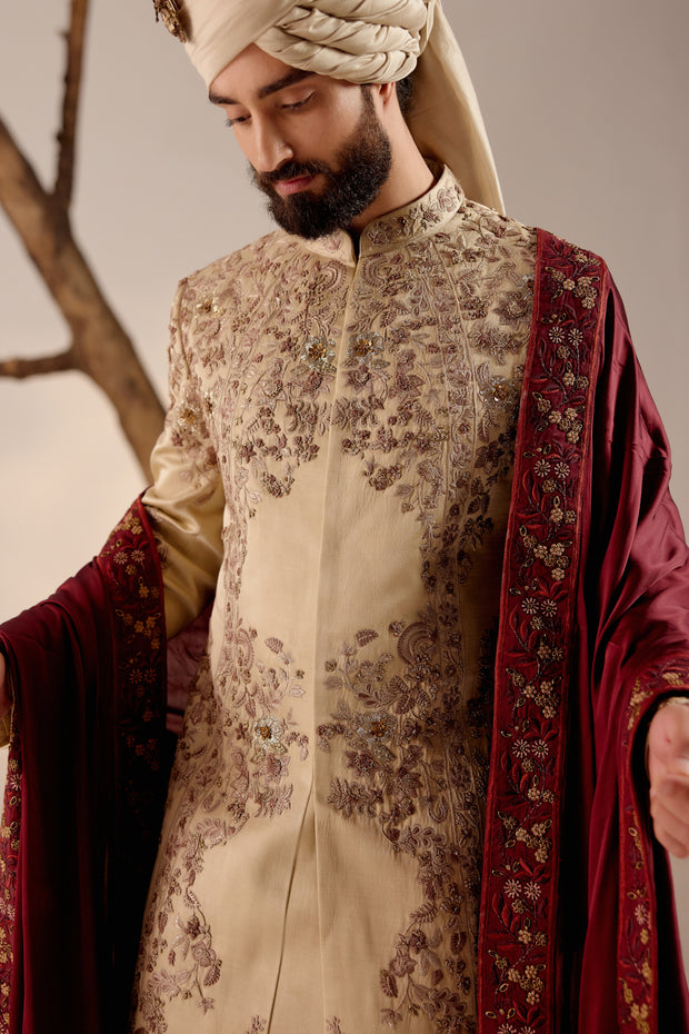 Introducing our masterpiece: the sand grey sherwani, intricately hand-embroidered with resham, silver threads, dabka, and zari, creating a captivating tapestry of textures and designs.