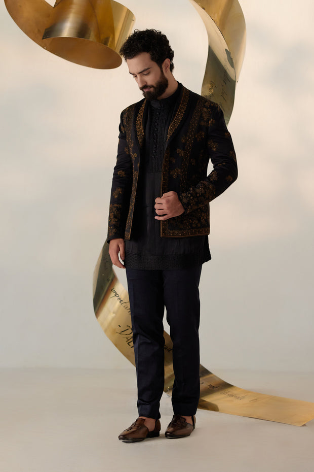 all-black short jacket set, elevated with exquisite gold zari work and a distinguished shawl collar lapel detail.
