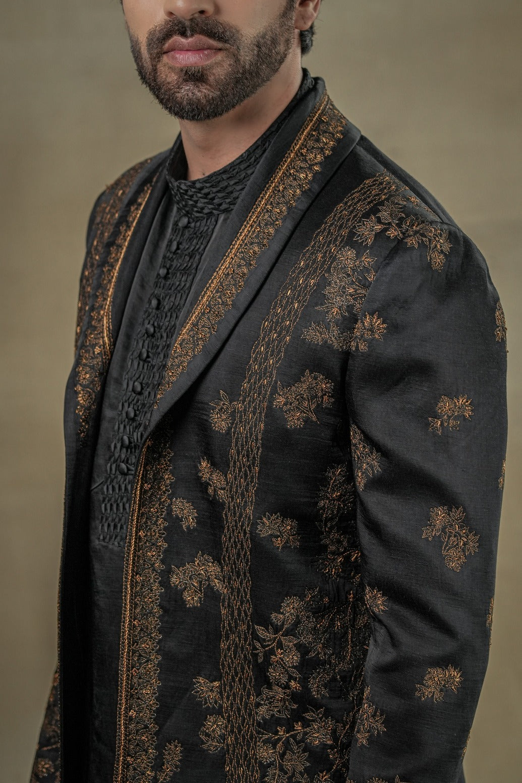 all-black short jacket set, elevated with exquisite gold zari work and a distinguished shawl collar lapel detail.