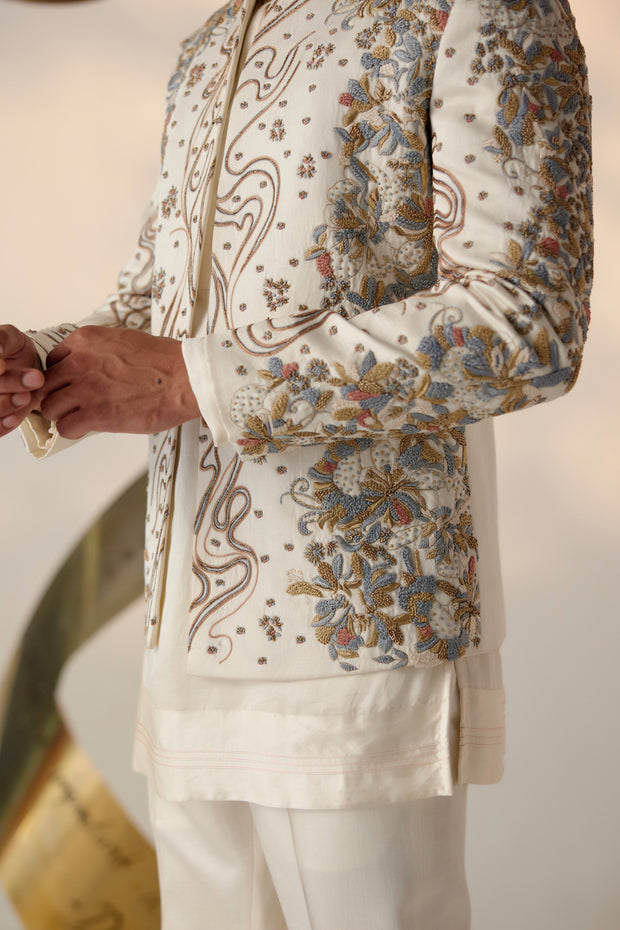 This exquisite piece is hand-embroidered with colorful resham threads, gold zari, dabka, and twisted line details, creating a vibrant and intricate design