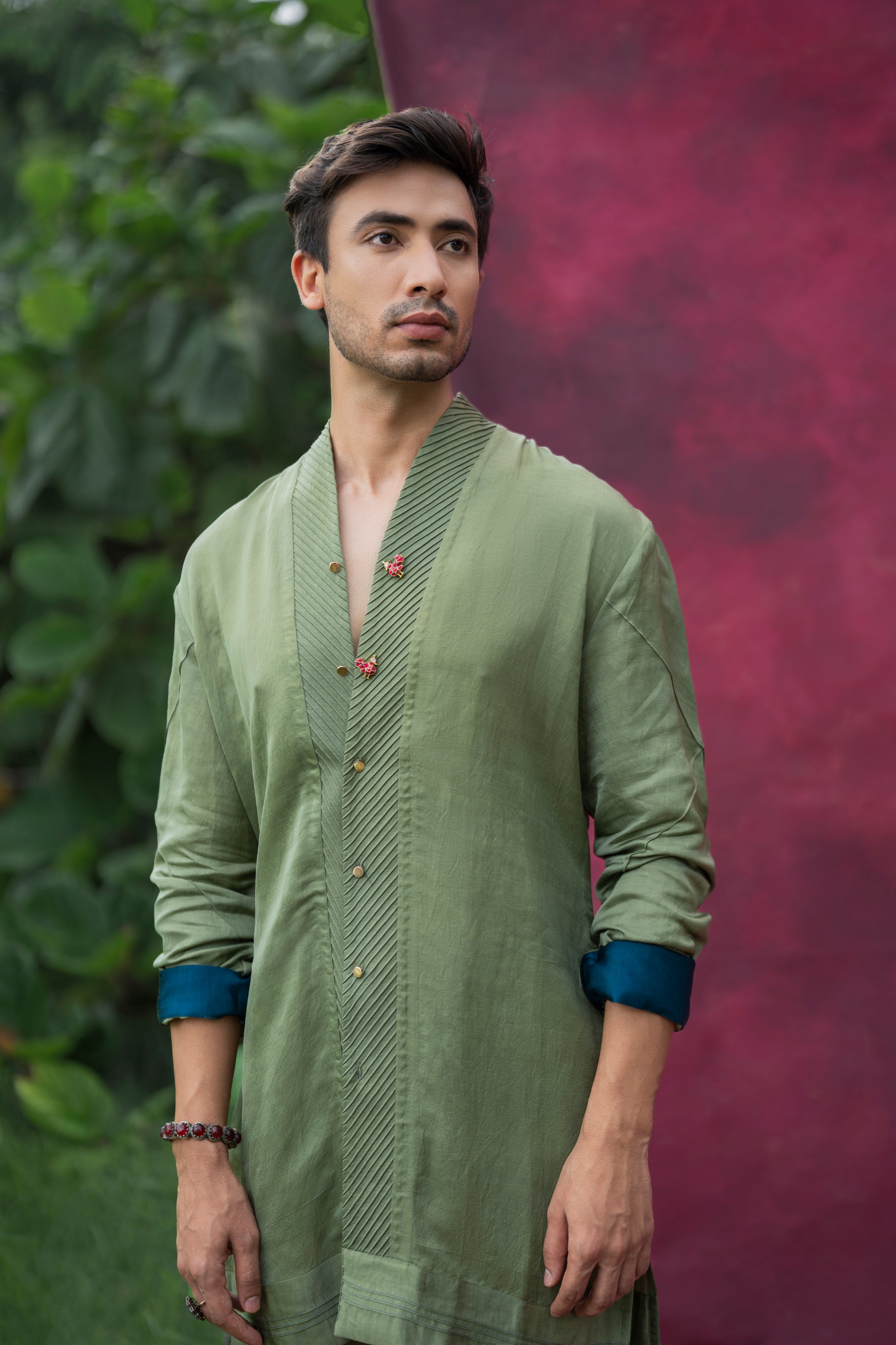 The Sage Kurta Set in a soothing sage green color, featuring a pin-tucked shawl collar and teal roll-up details, paired with matching tone-on-tone tapered trousers