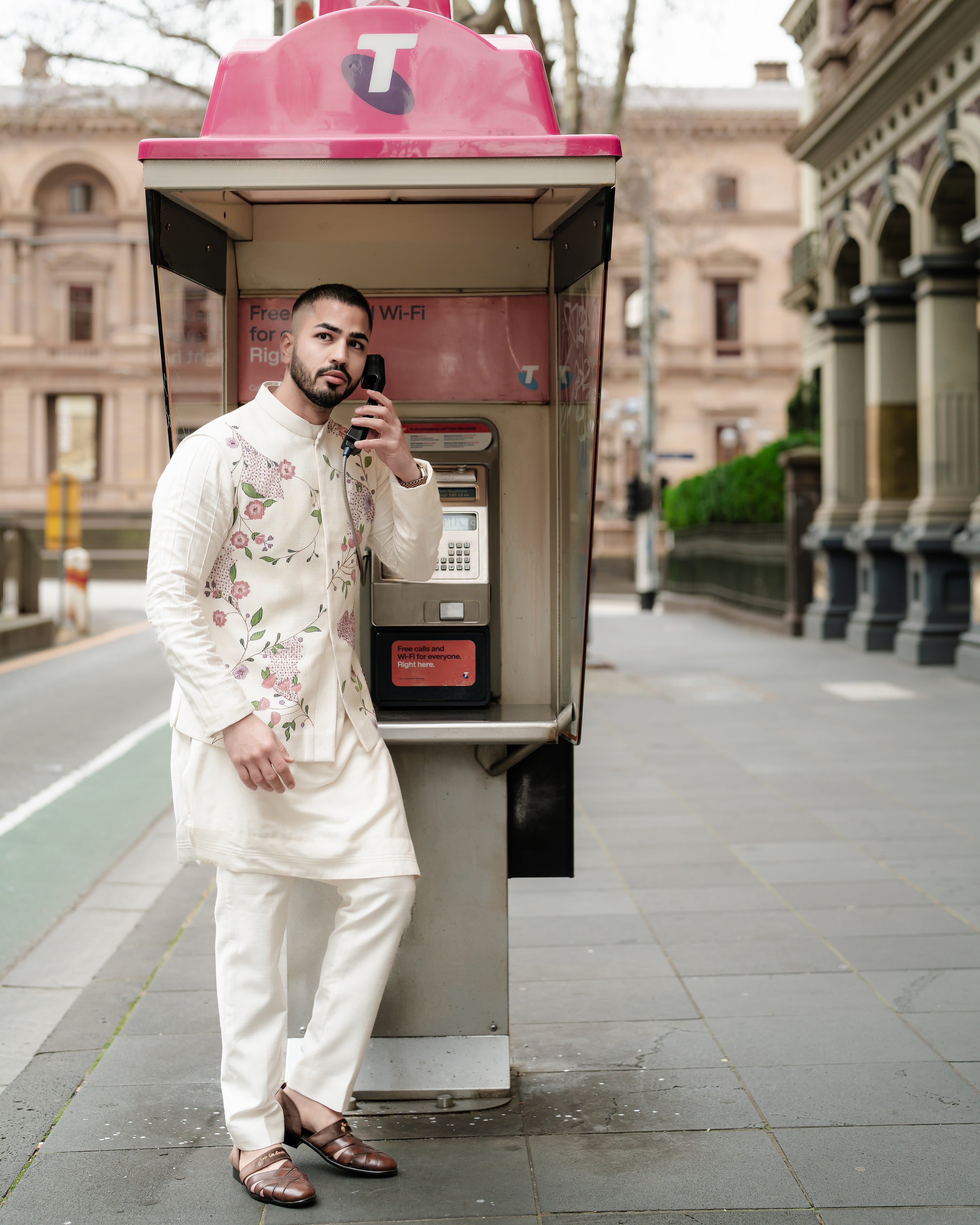 Porcelain-toned Nehru jacket made from textured slub silk, featuring intricate hand-painted floral designs and 3D gold embellishments, styled with a shoulder button kurta and tapered trousers