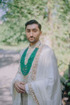 Ivory sherwani featuring a light gold zari meadow flower pattern and intricate pitta work, complemented by a matching kurta, churidar, stole, and safa