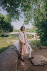 Linen silk ivory sherwani with delicate tone-on-tone floral embroidery using dori work and katdana, paired with a flowy anarkali kurta, churidar, embroidered kamarbandh, and soft old rose stole