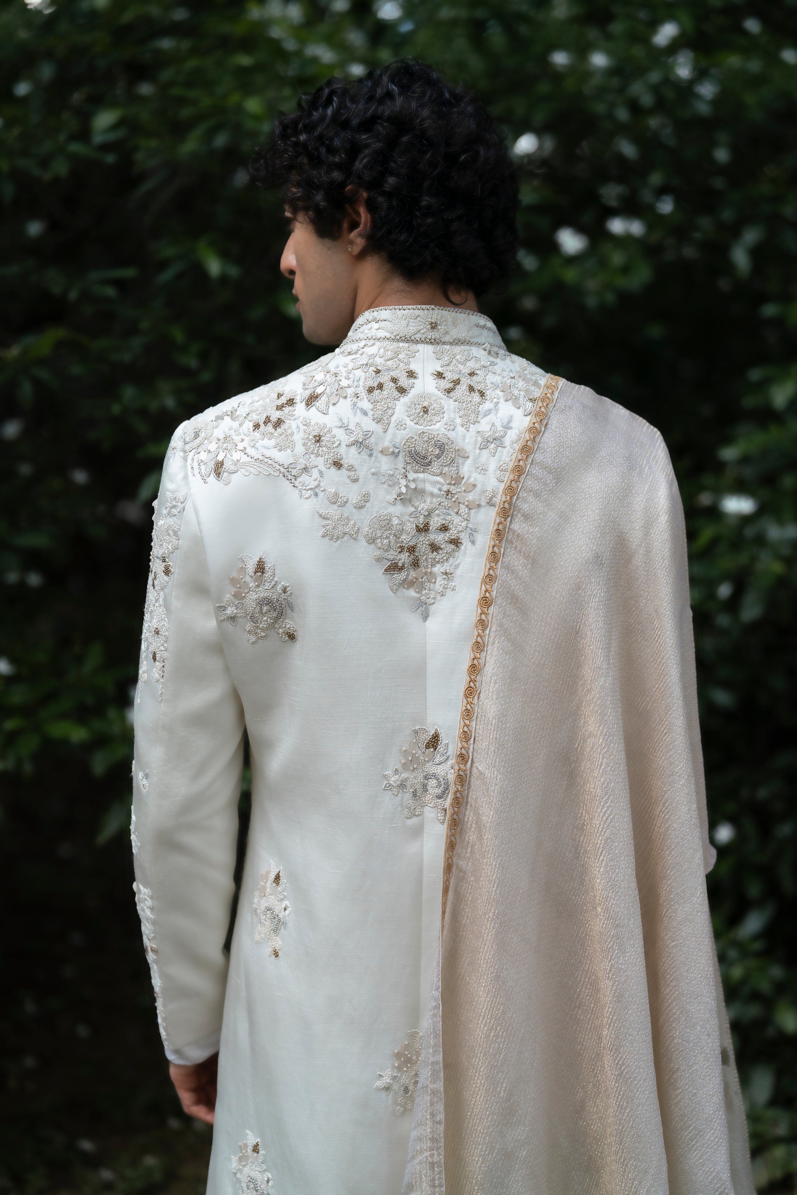 Close-up of the 3D floral embroidery on the Wisteria White sherwani, highlighting the tone-on-tone dori work and luxurious texture on a linen silk base.