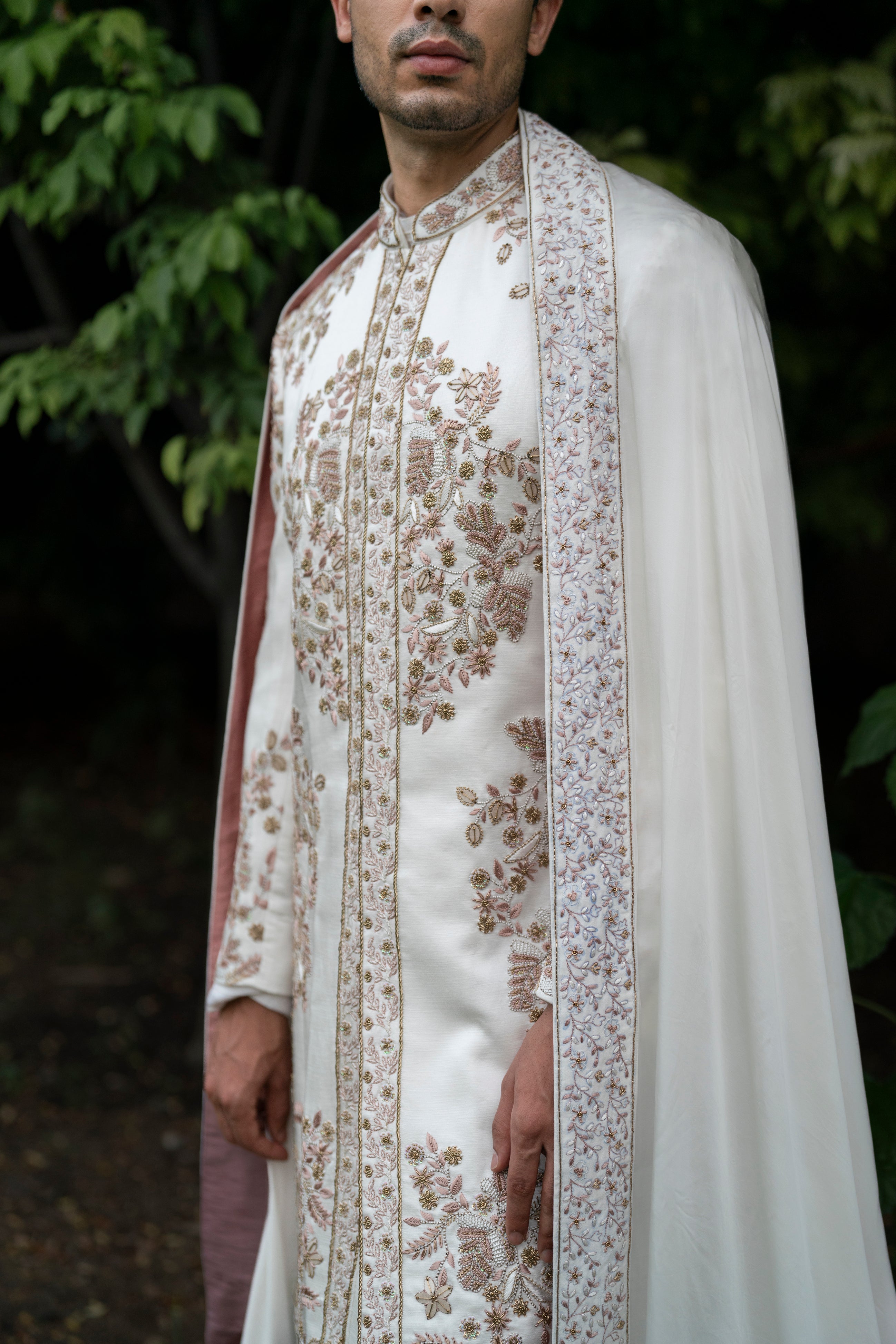 Close-up of the intricate hand-embroidered details on the Ivory Fleur sherwani, showcasing delicate ivory and champagne threads, sequins, and gold accents