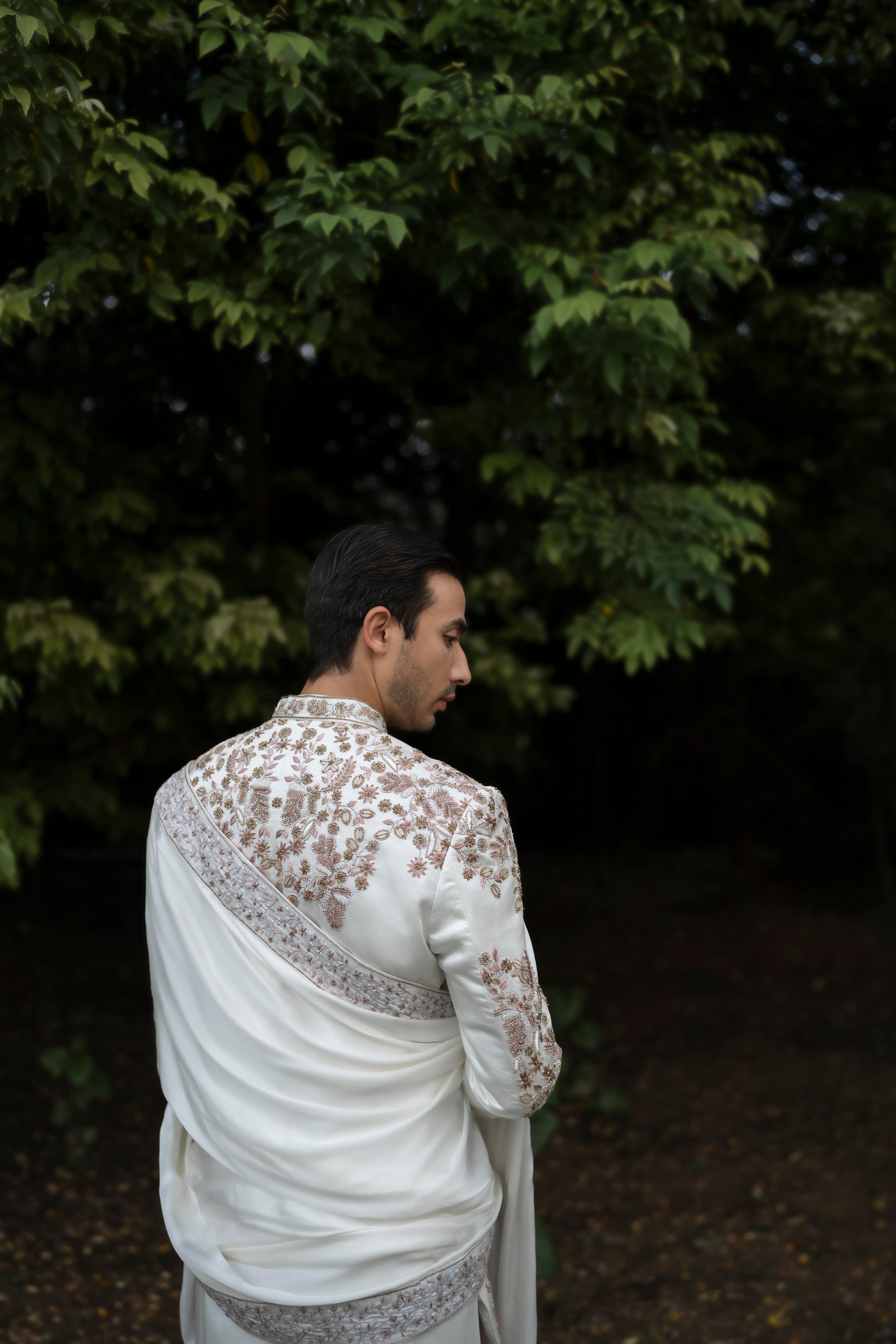 Back view of the Ivory Fleur sherwani, highlighting the elegant placement embroidery and subtle shimmer of sequins and gold elements on the linen silk base.