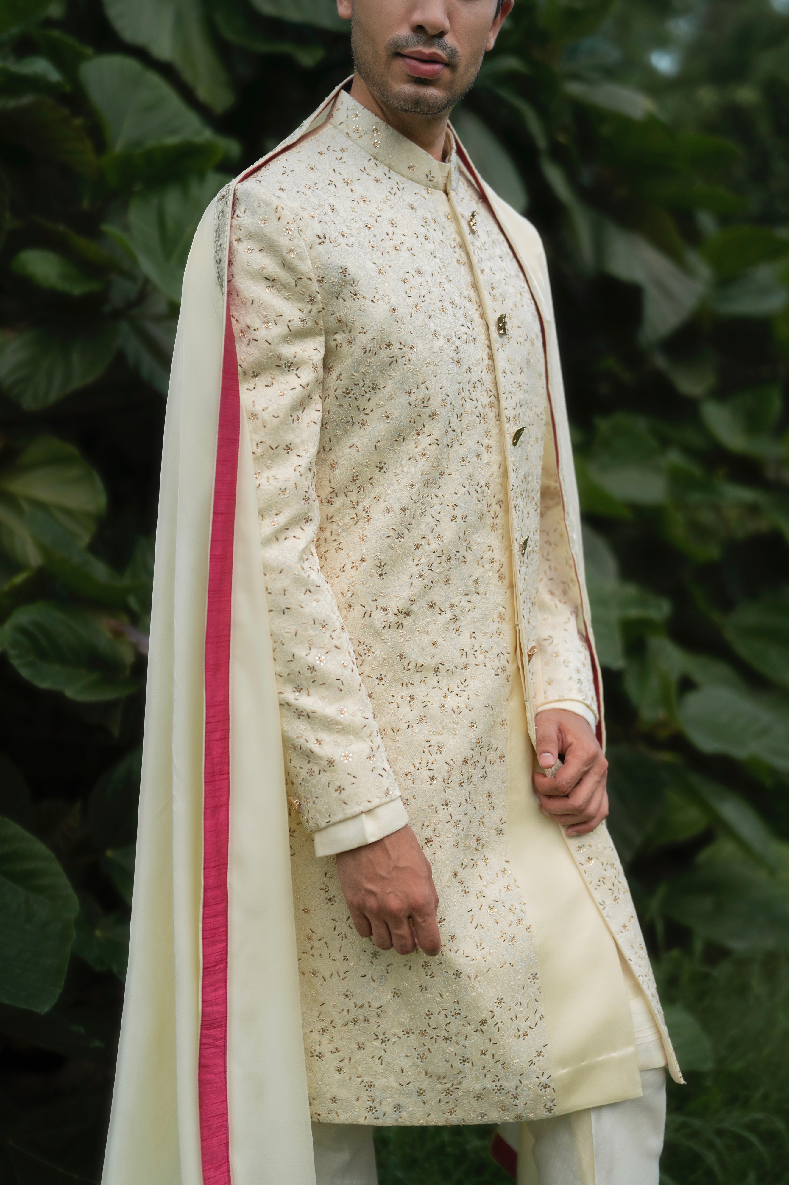 Linen silk sherwani in butter yellow, featuring hand-embroidered tone-on-tone aari thread work with delicate light gold mukaish highlights, paired with a kurta, churidar, and a bold pink fuchsia stole and safa