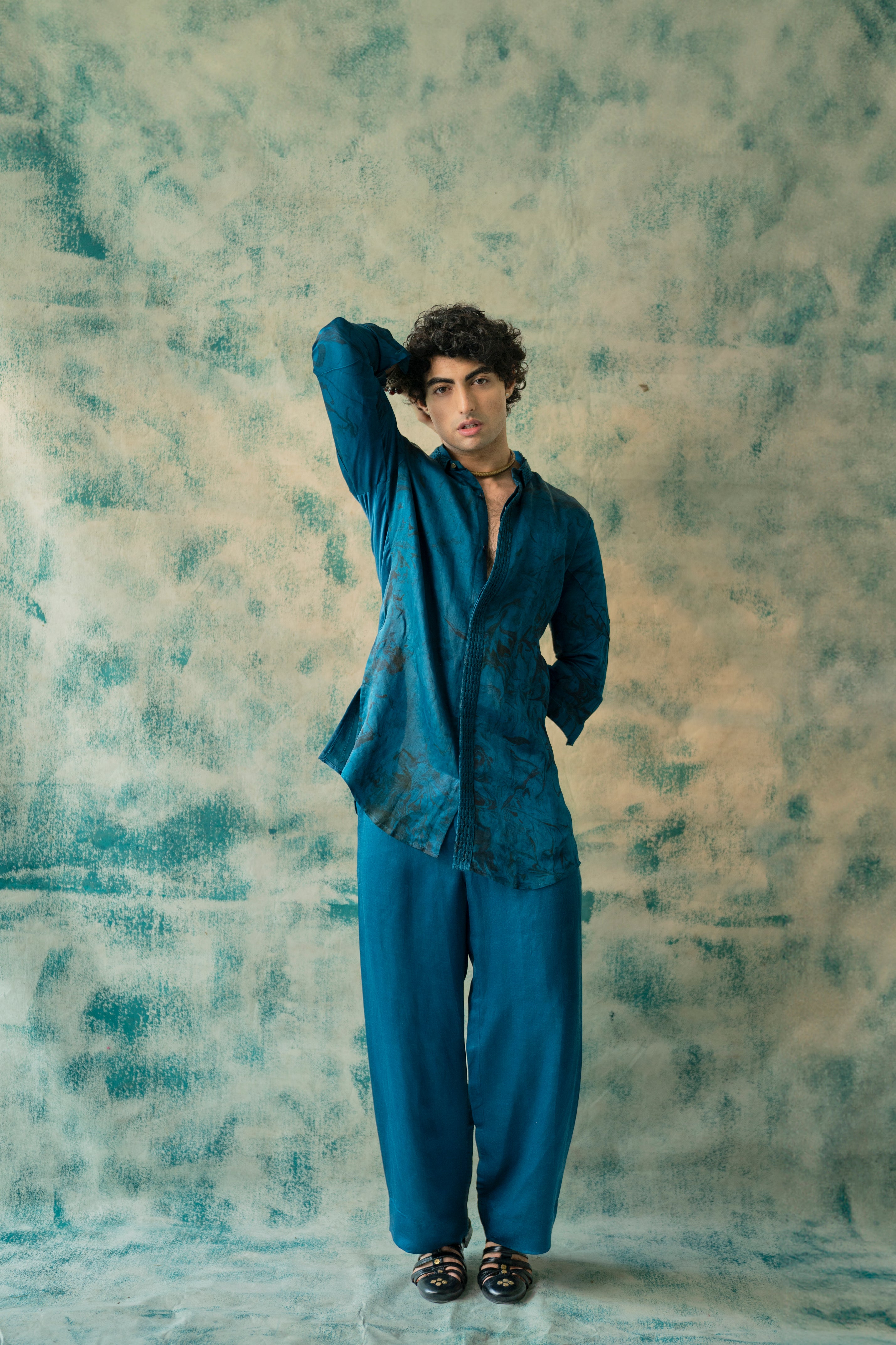 Presenting Blue Thistel kurta set in Teal color with double cuban collar, pintuck detailed front placket, and marble dye print. Paired with tone-on-tone wide-leg trousers.