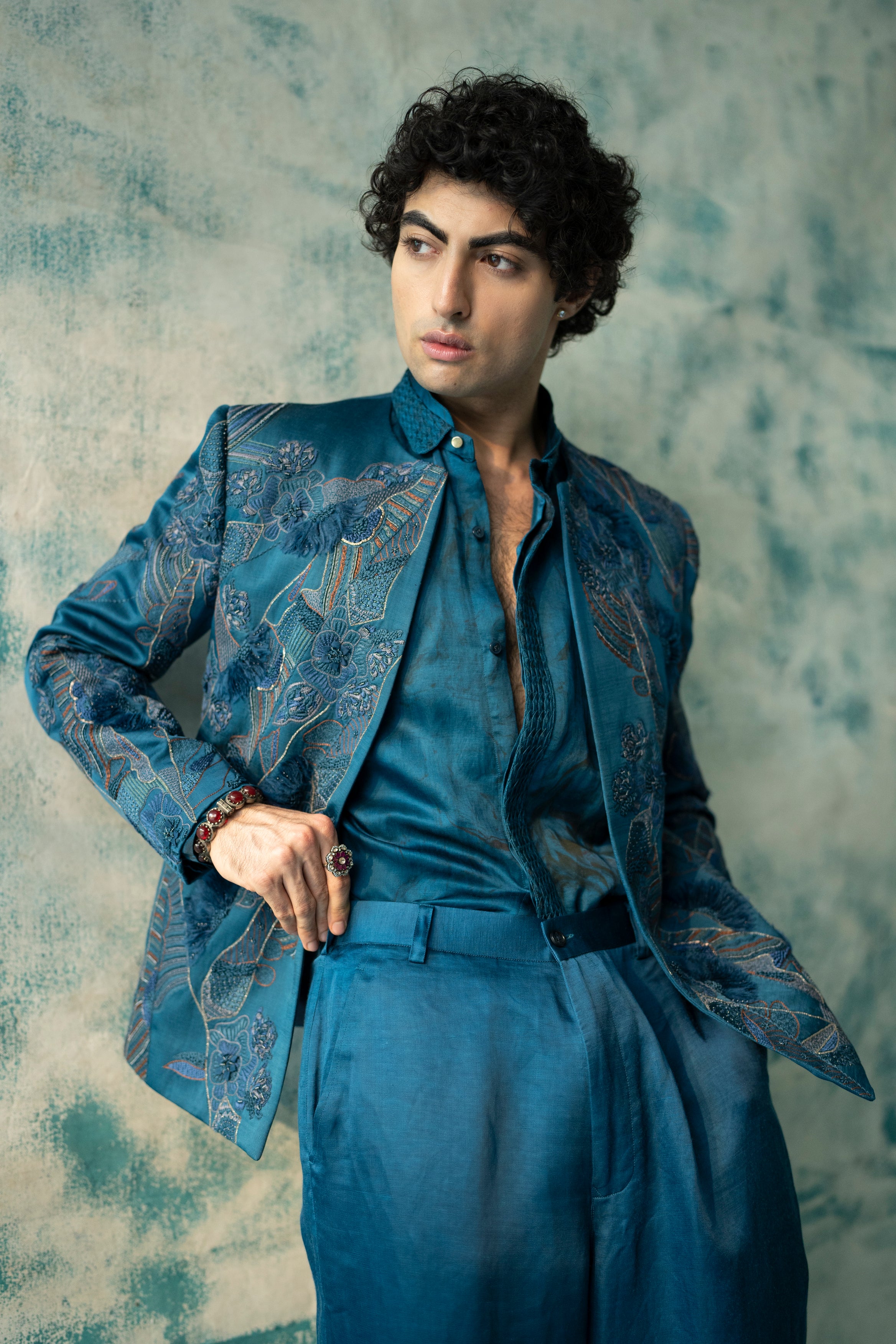 The Thistle short jacket set in teal, featuring a marble dye technique inspired by Monet's color palette, paired with a short-length shirt style kurta and straight leg trousers