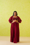 Intricate resham embroidery details on the crop top, highlighting the exquisite craftsmanship of this maroon ensemble.