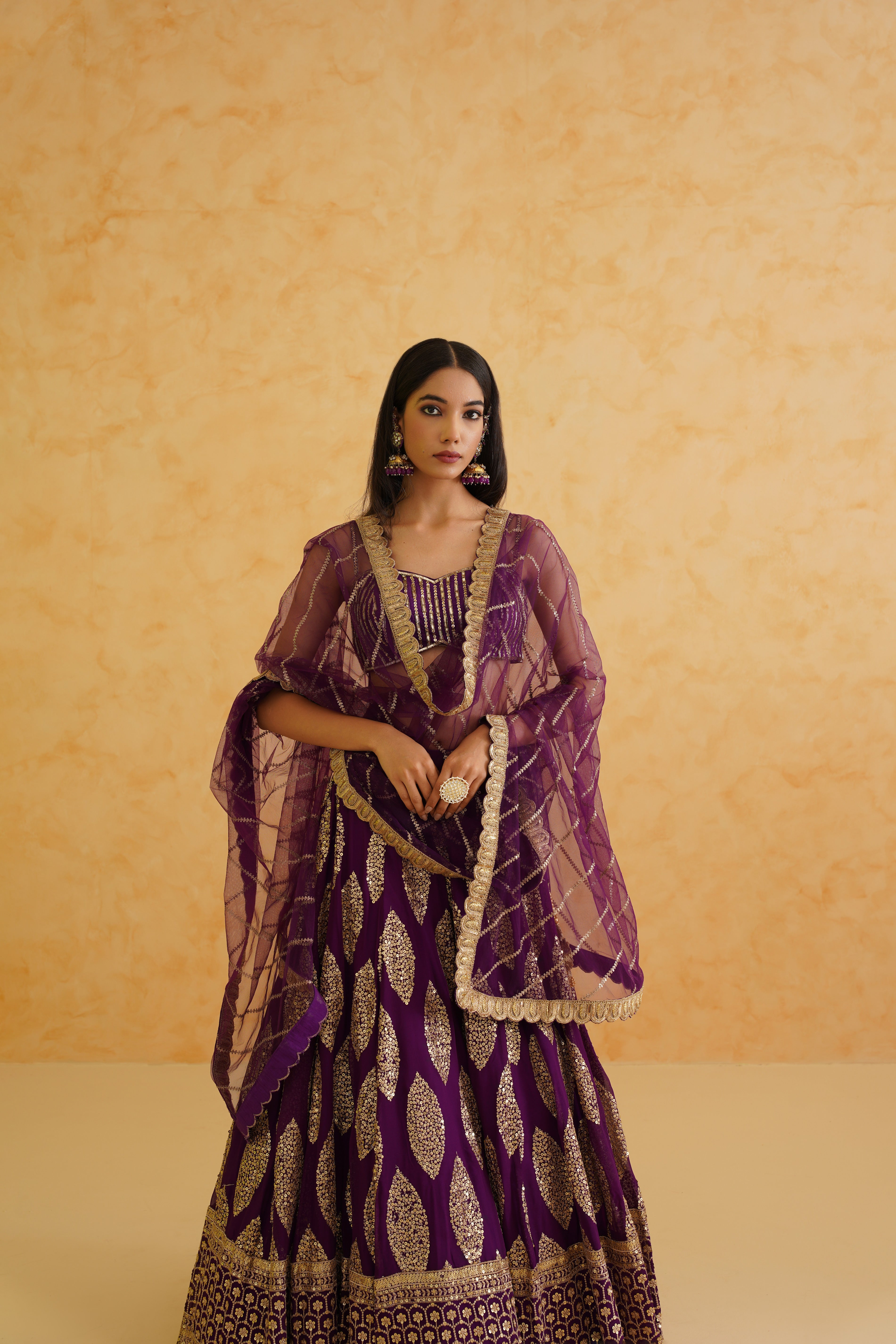 Stunning purple georgette lehenga featuring an intricately embroidered blouse adorned with crystals, stones, and cutdana details.