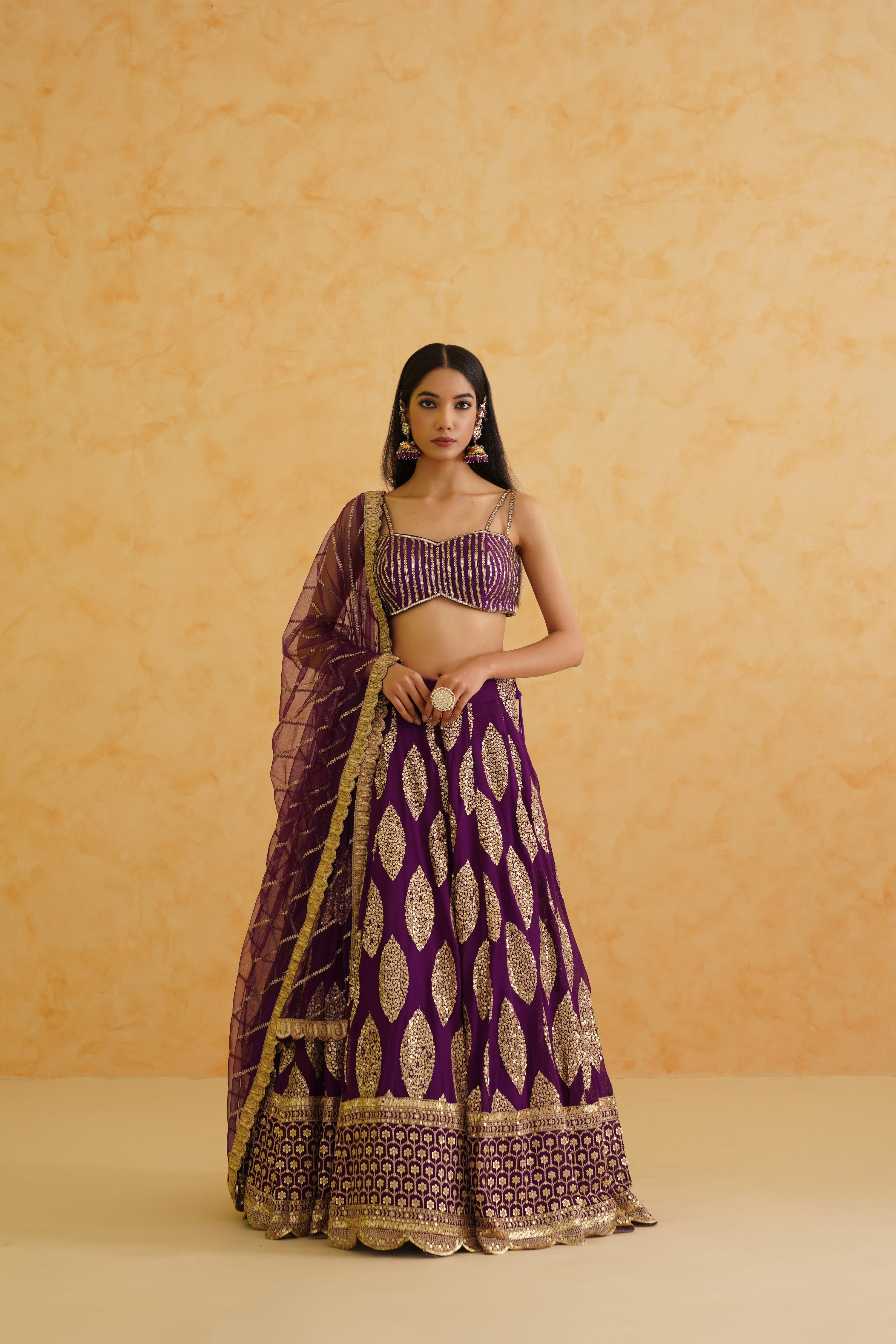 Complete ensemble with a matching net dupatta, adding a finishing touch to the glamorous purple lehenga look.