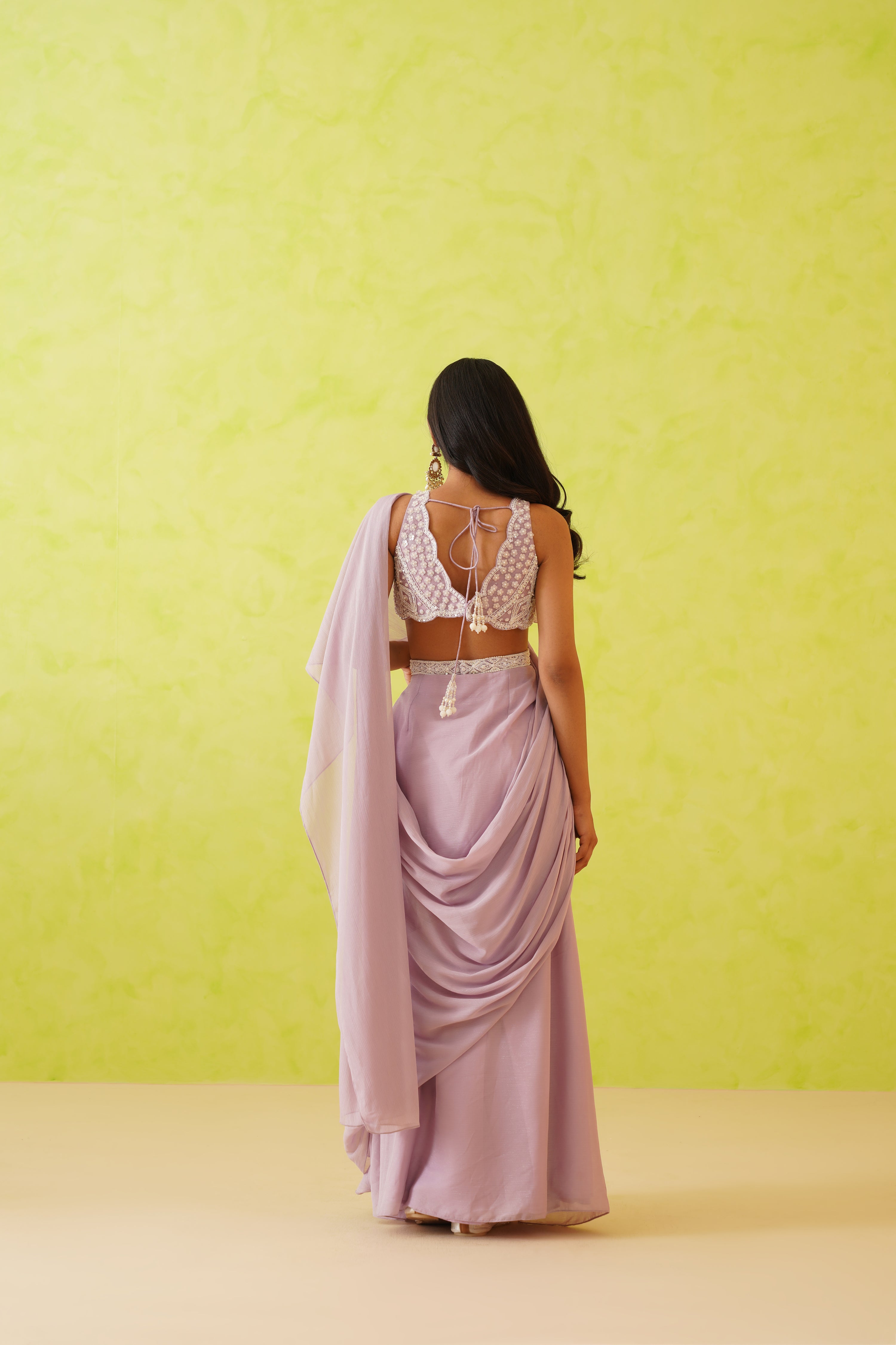 Intricate pearl and crystal embellishments on the blouse enhance the overall elegance of the mauve draped saree ensemble.