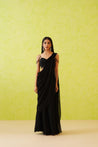 Elegant black draped saree with a full-length flowy silhouette, paired with an embellished blouse featuring floral patterns in black tonal sequins, crystals, and pearls.