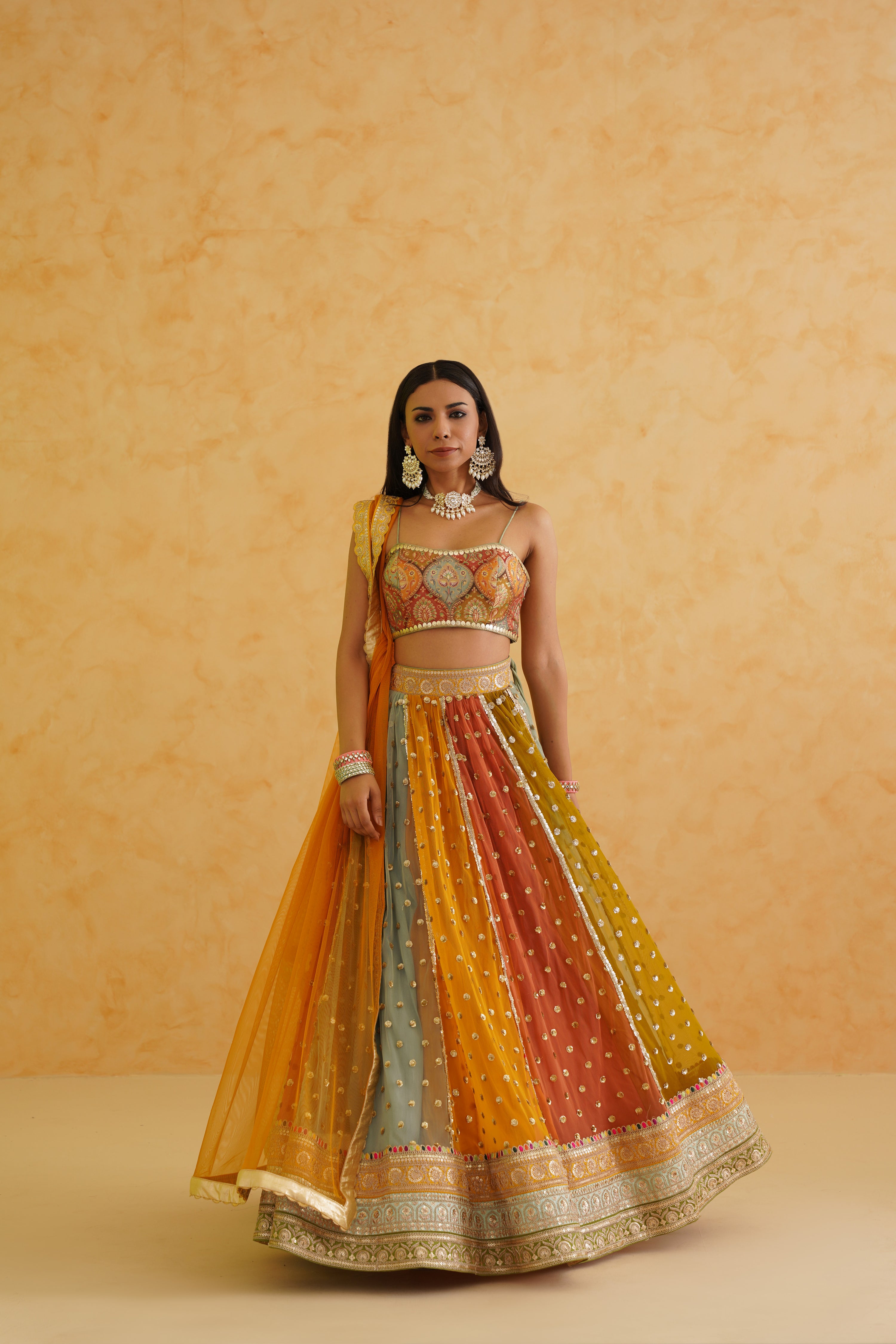 Vibrant multi-colored net fabric lehenga paired with a stylish brocade blouse, adding a touch of glamour to any occasion.