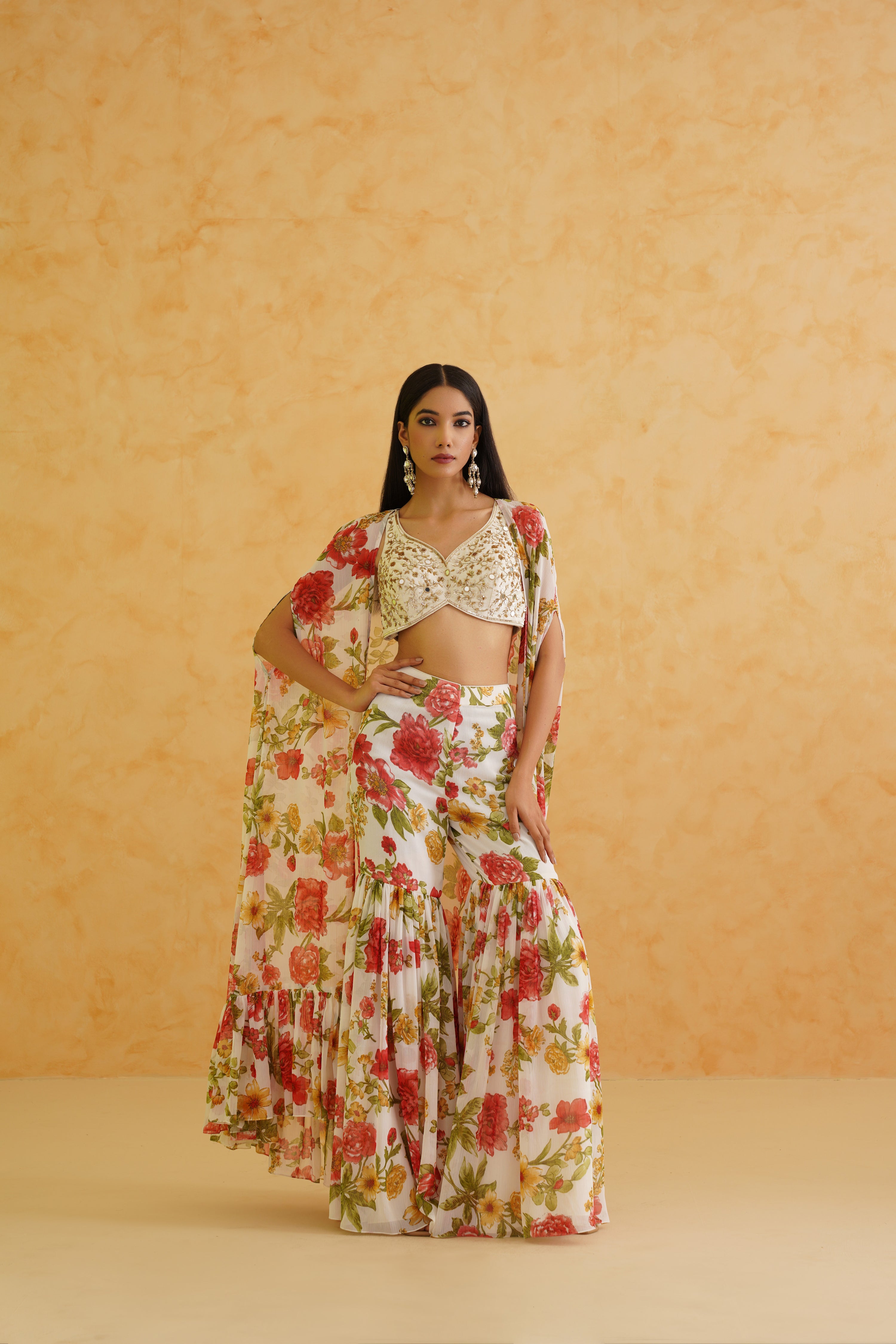 Exquisite white crop top and garara set showcasing intricate zari embroidery, accented by a printed jacket for added elegance.