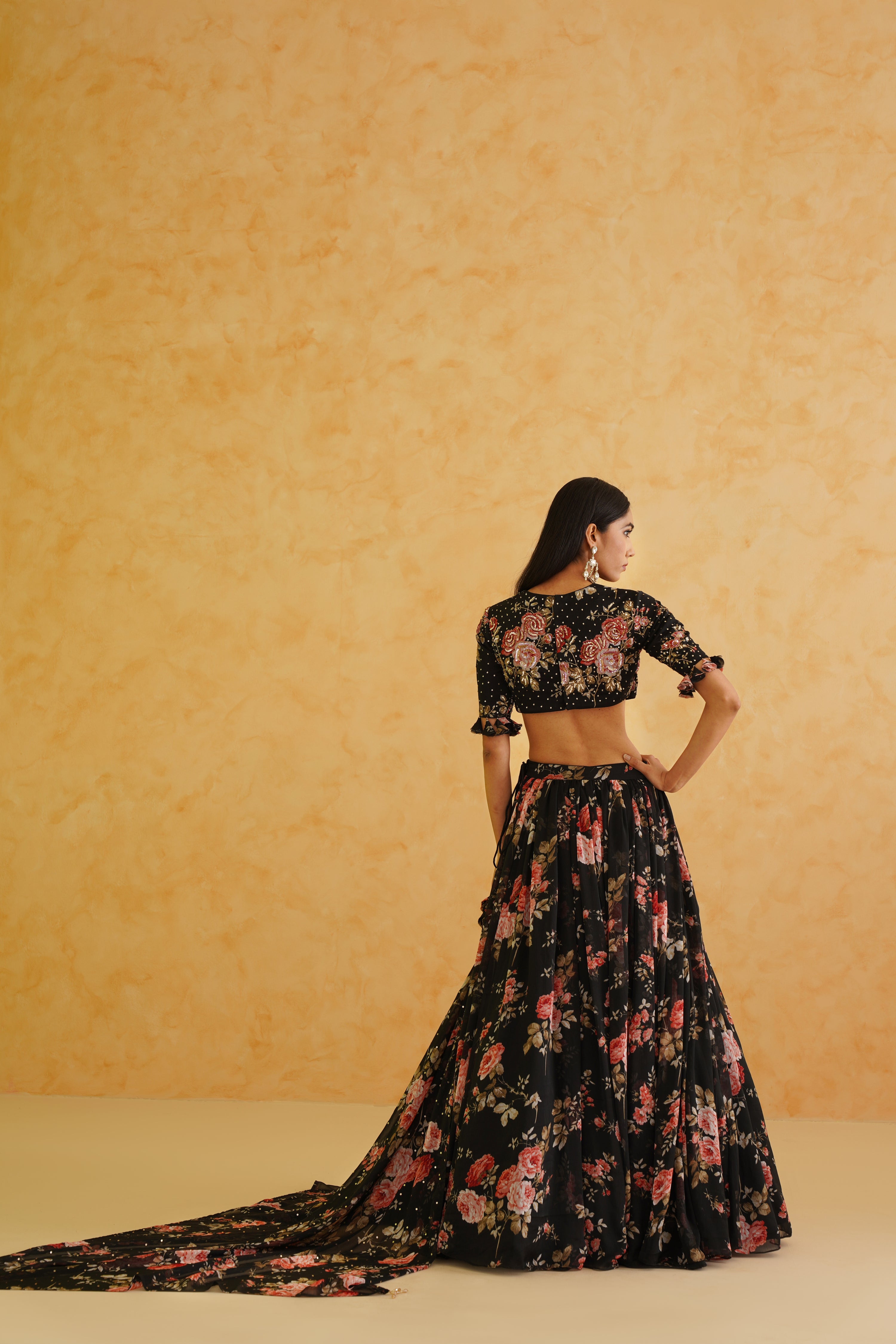 Stunning black lehenga adorned with a gold embroidered floral blouse, complemented by a black floral printed dupatta for a refined, stylish ensemble.