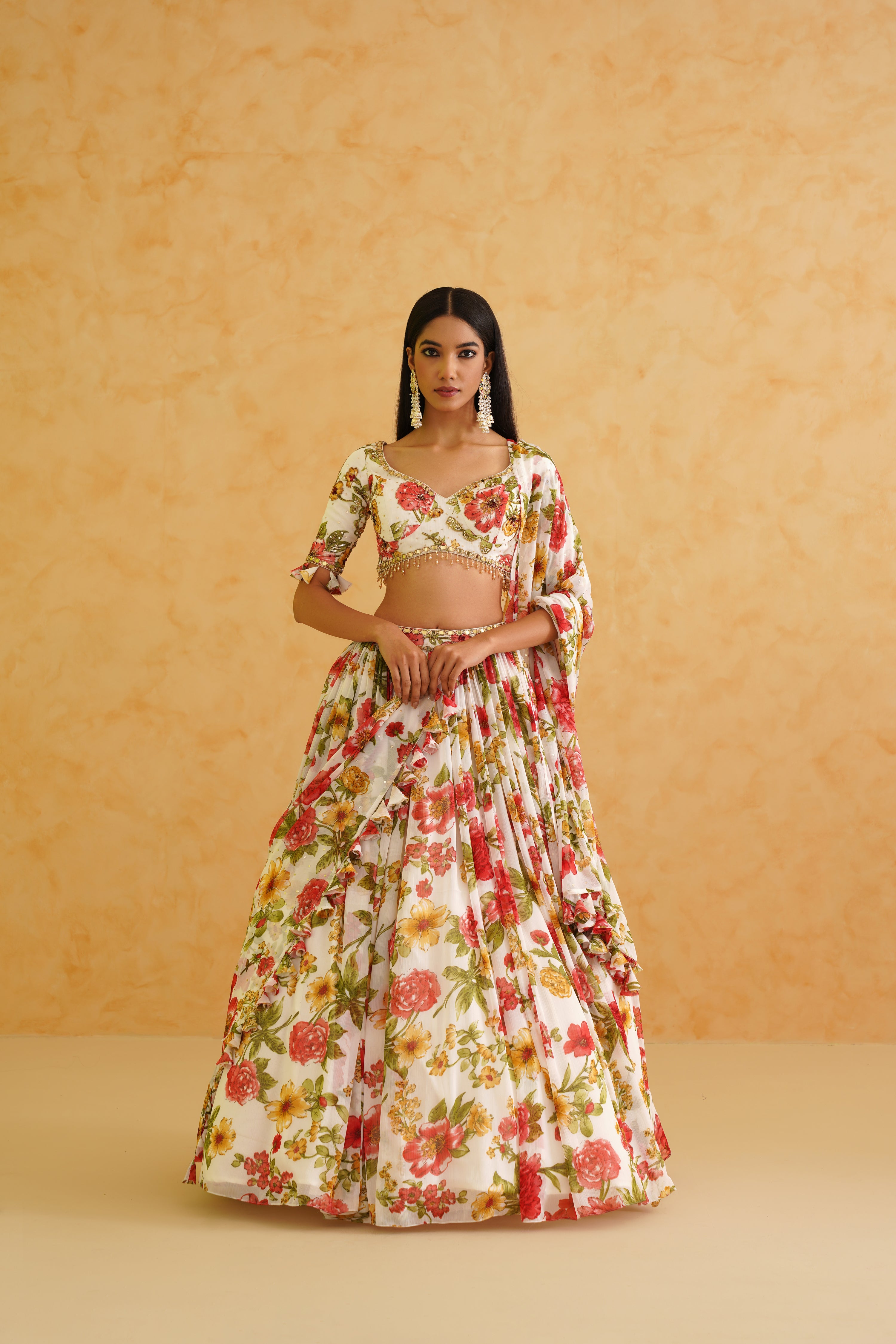 Elegant white georgette lehenga with a gold crystal and sequin-embroidered floral blouse, paired with a matching floral printed dupatta for a sophisticated look.