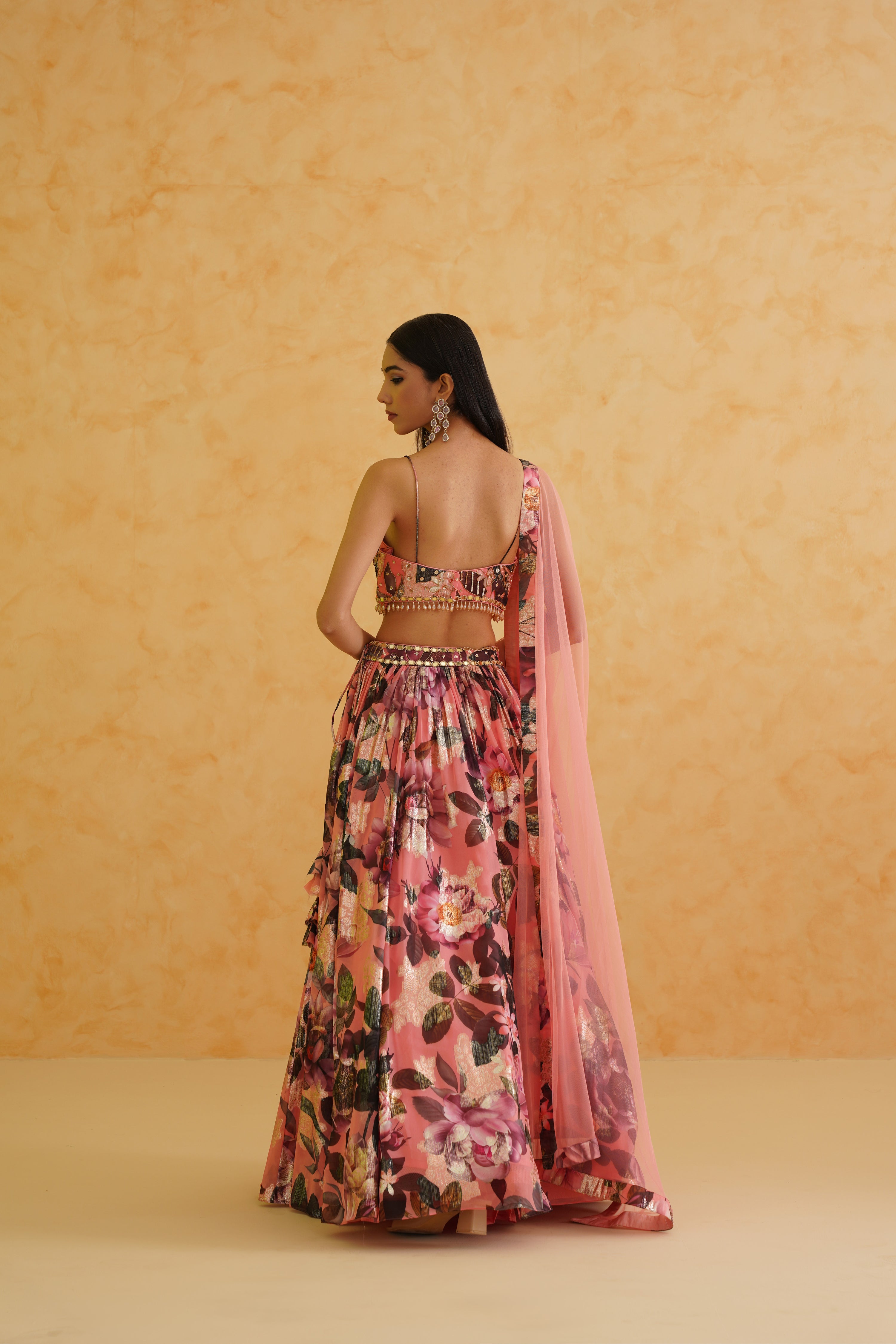 Stunning pink printed georgette lehenga set featuring an intricately embellished floral blouse and paired with a soft pink net dupatta for a complete ensemble.