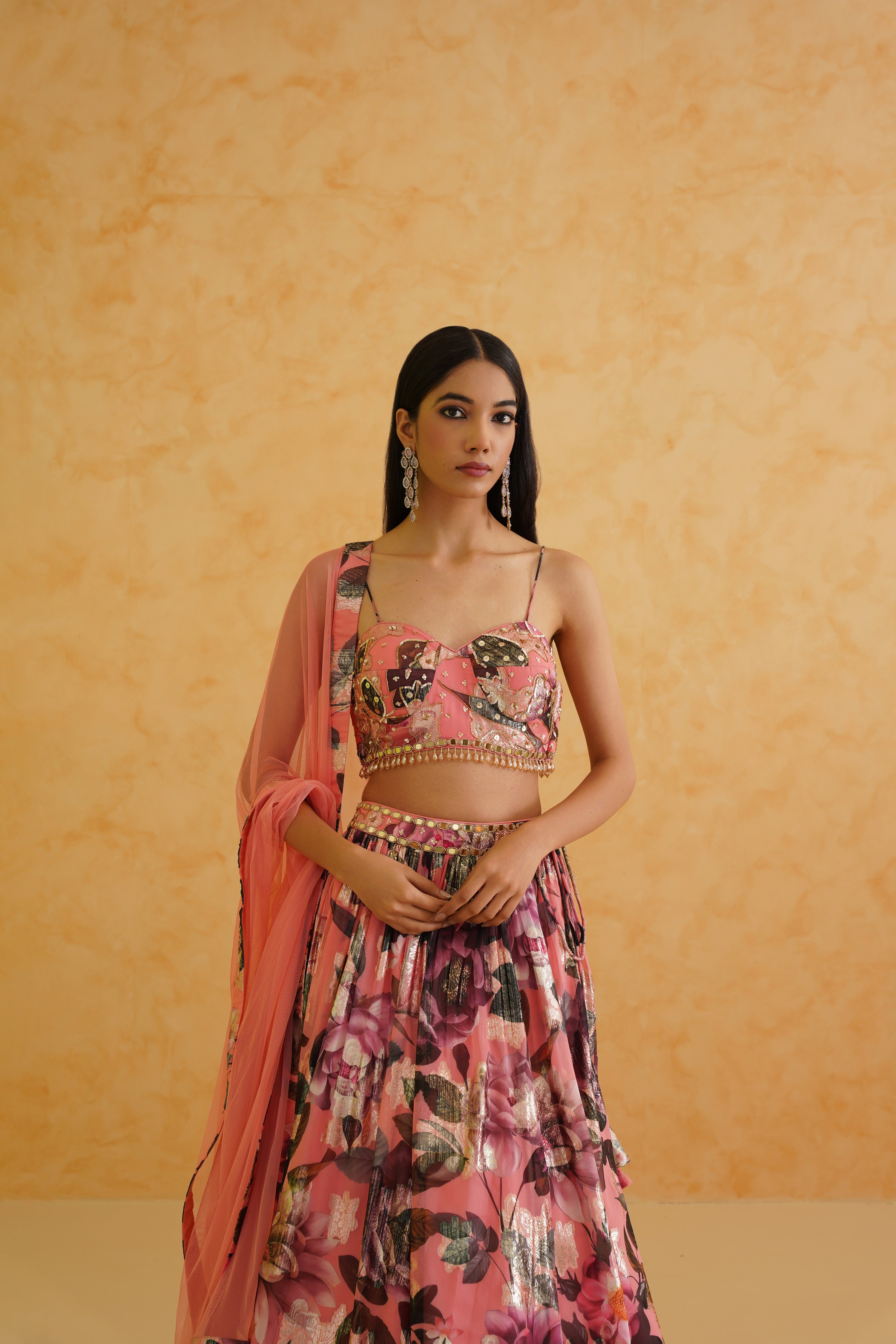 Pink printed georgette lehenga with a beautifully embroidered gold floral blouse, styled with a coordinating pink net dupatta for an elegant and comfortable outfit.