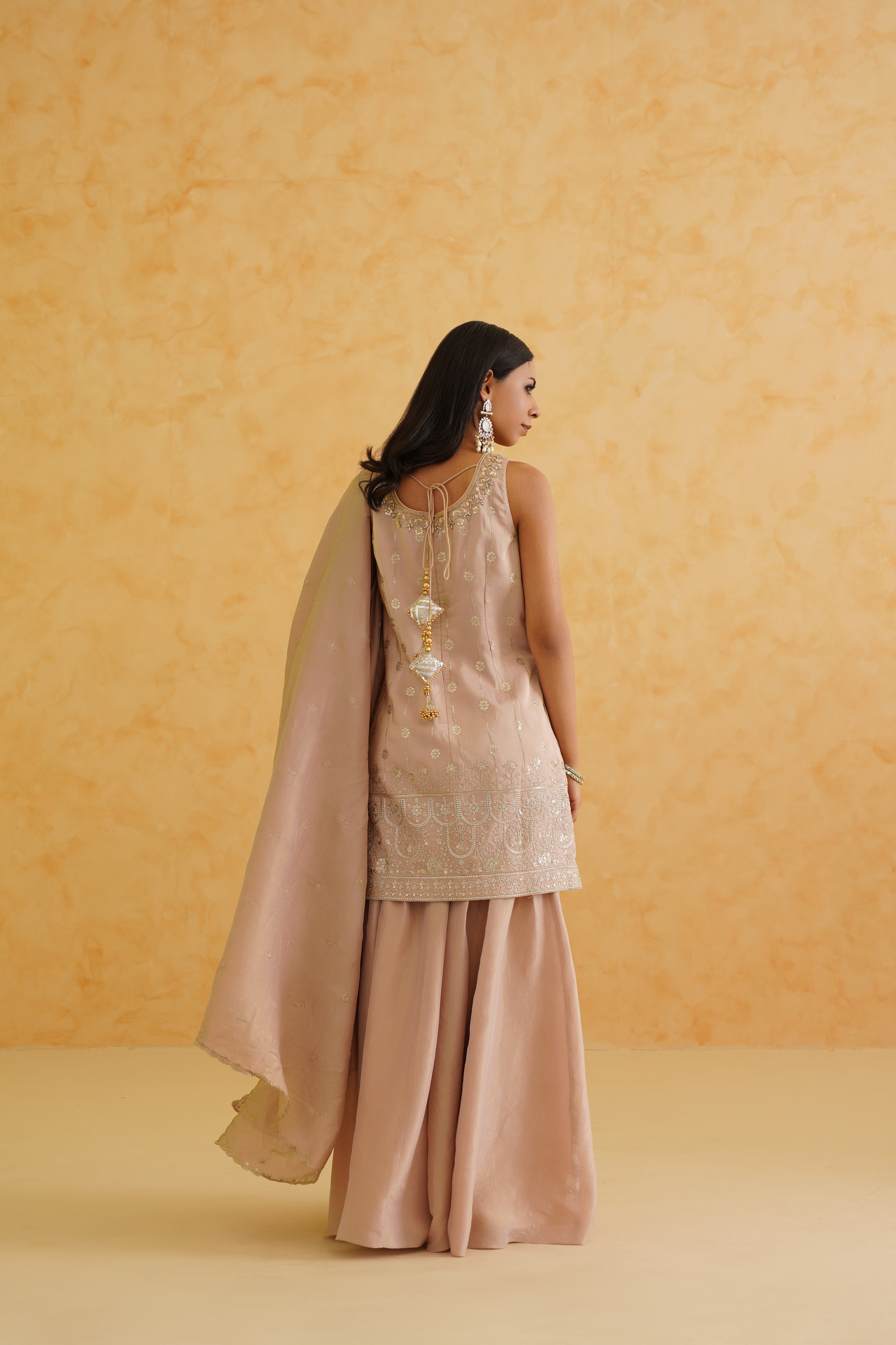 A romantic blush pink sharara with intricate gold work for a glamorous look.