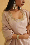 Traditional Indian wedding attire in a soft blush pink hue with shimmering embellishments.