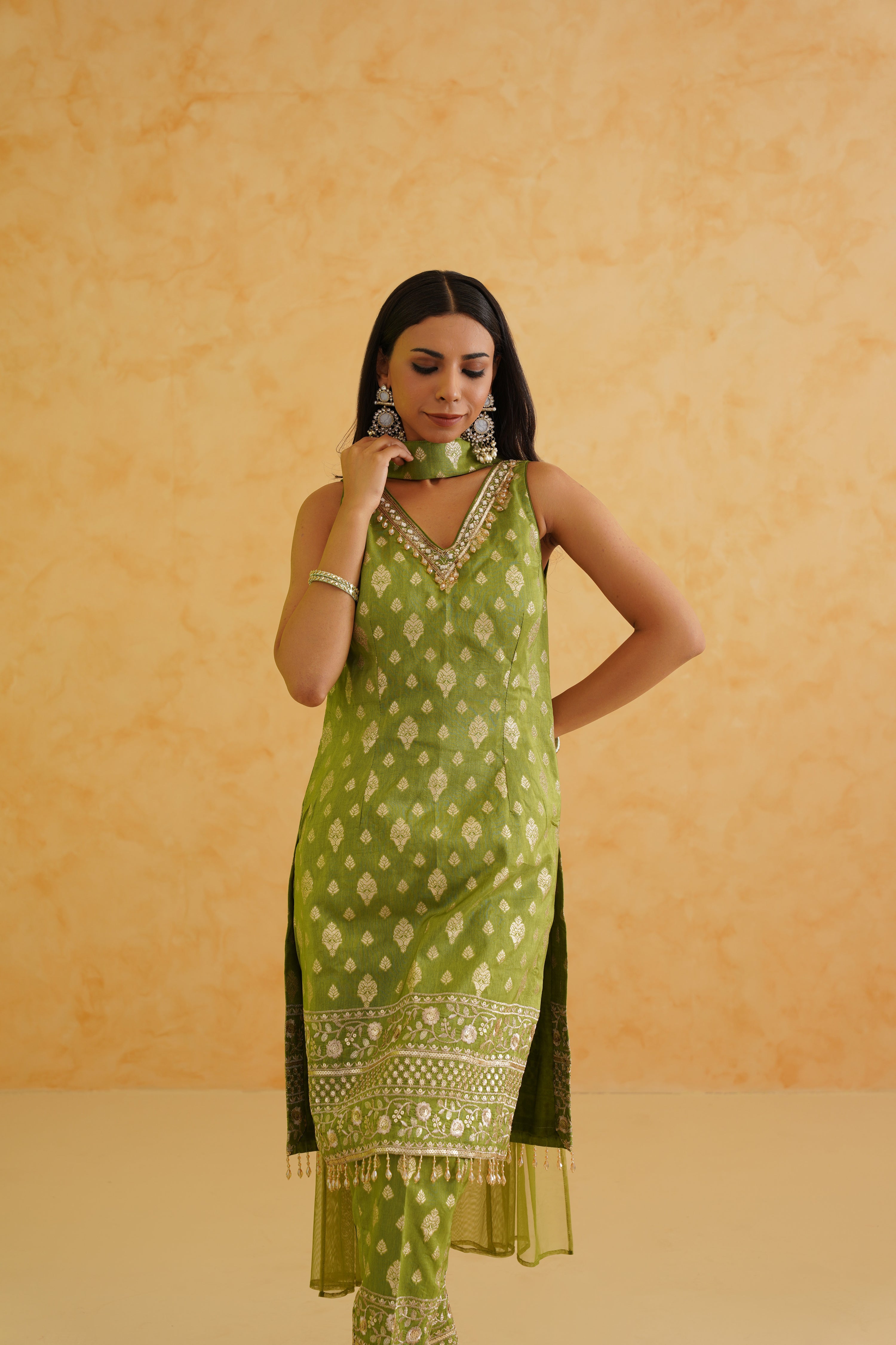 A stylish green brocade kurti set with matching pants and a net dupatta.