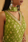 Traditional Indian attire in a vibrant green color with dazzling embellishments.