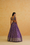 A captivating purple brocade lehenga with a touch of glamour, featuring intricate gold embroidery and a flowing dupatta.