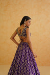 A sophisticated purple brocade lehenga with delicate gold embellishments, offering a timeless and elegant look.