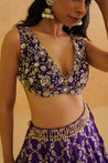 A stunning purple brocade lehenga with intricate gold crystal, sequin, and beadwork, perfect for special occasions.