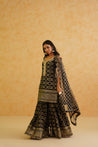 A luxurious black brocade kurti set featuring a flowy garara and a matching net dupatta, ideal for weddings and parties.