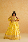 A sophisticated yellow brocade lehenga set that exudes elegance and style, perfect for any special occasion.