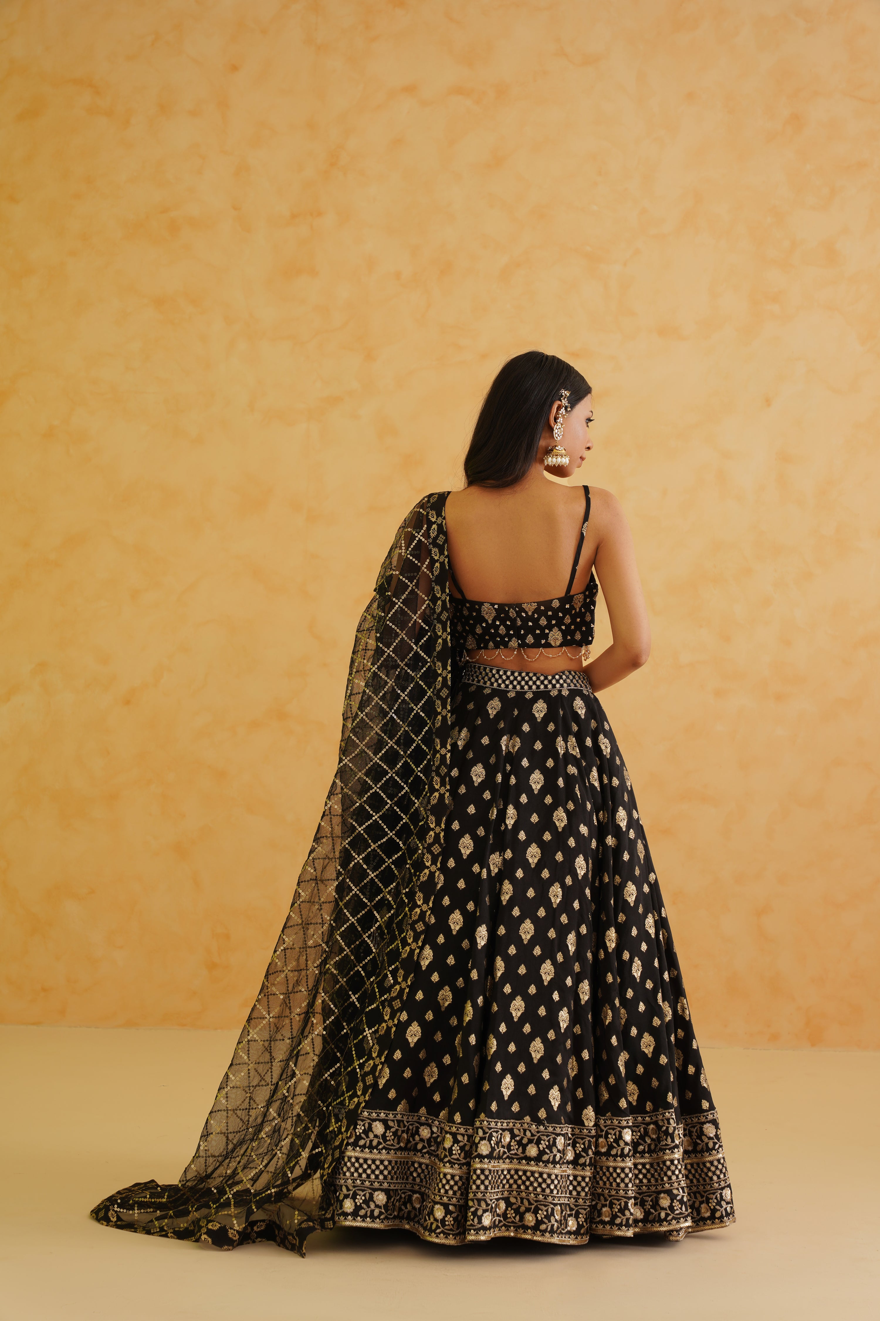 A captivating black brocade lehenga with a touch of glamour, featuring intricate embroidery and a flowing dupatta.