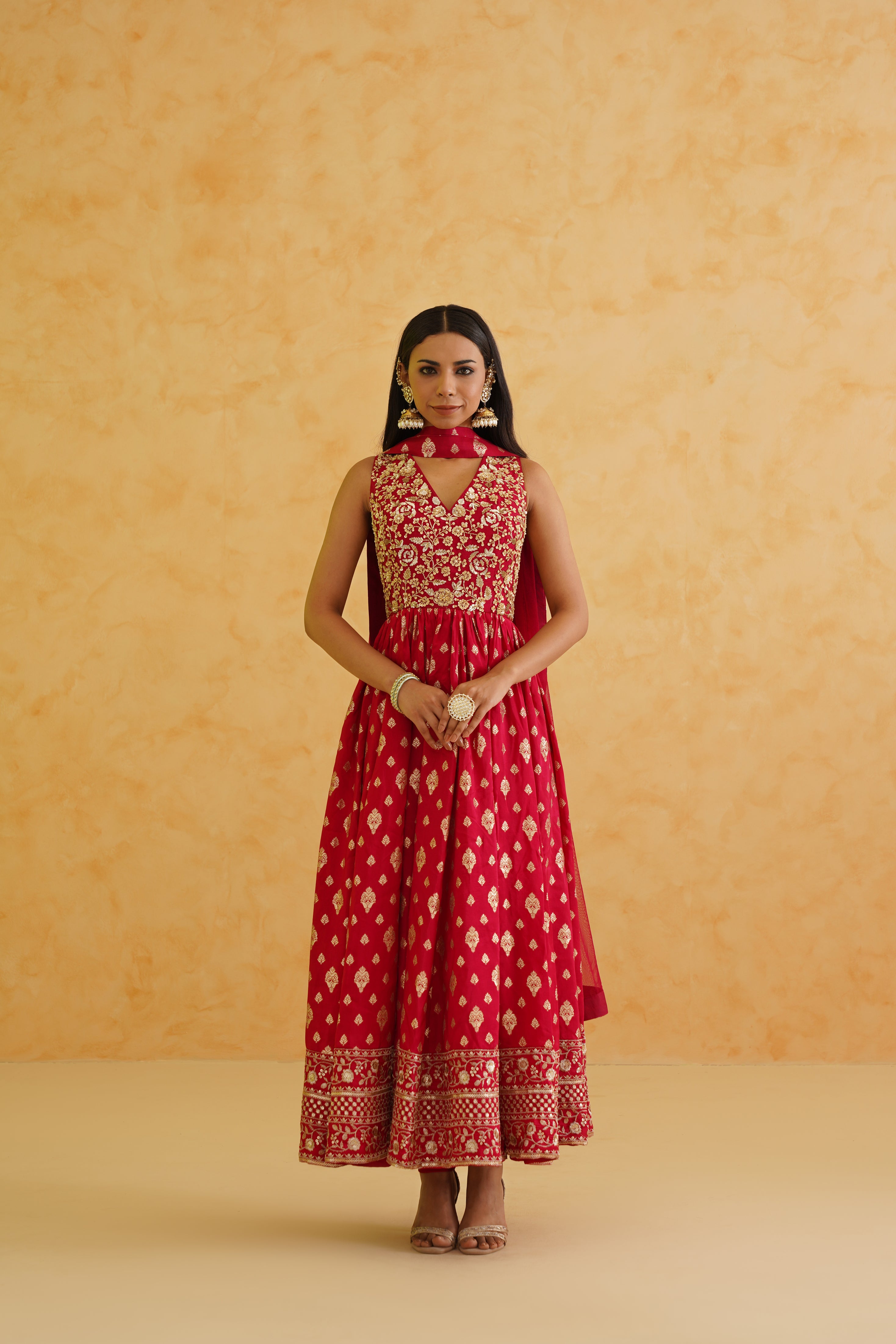 A stunning red brocade anarkali and churidar set with intricate embroidery, perfect for special occasions.