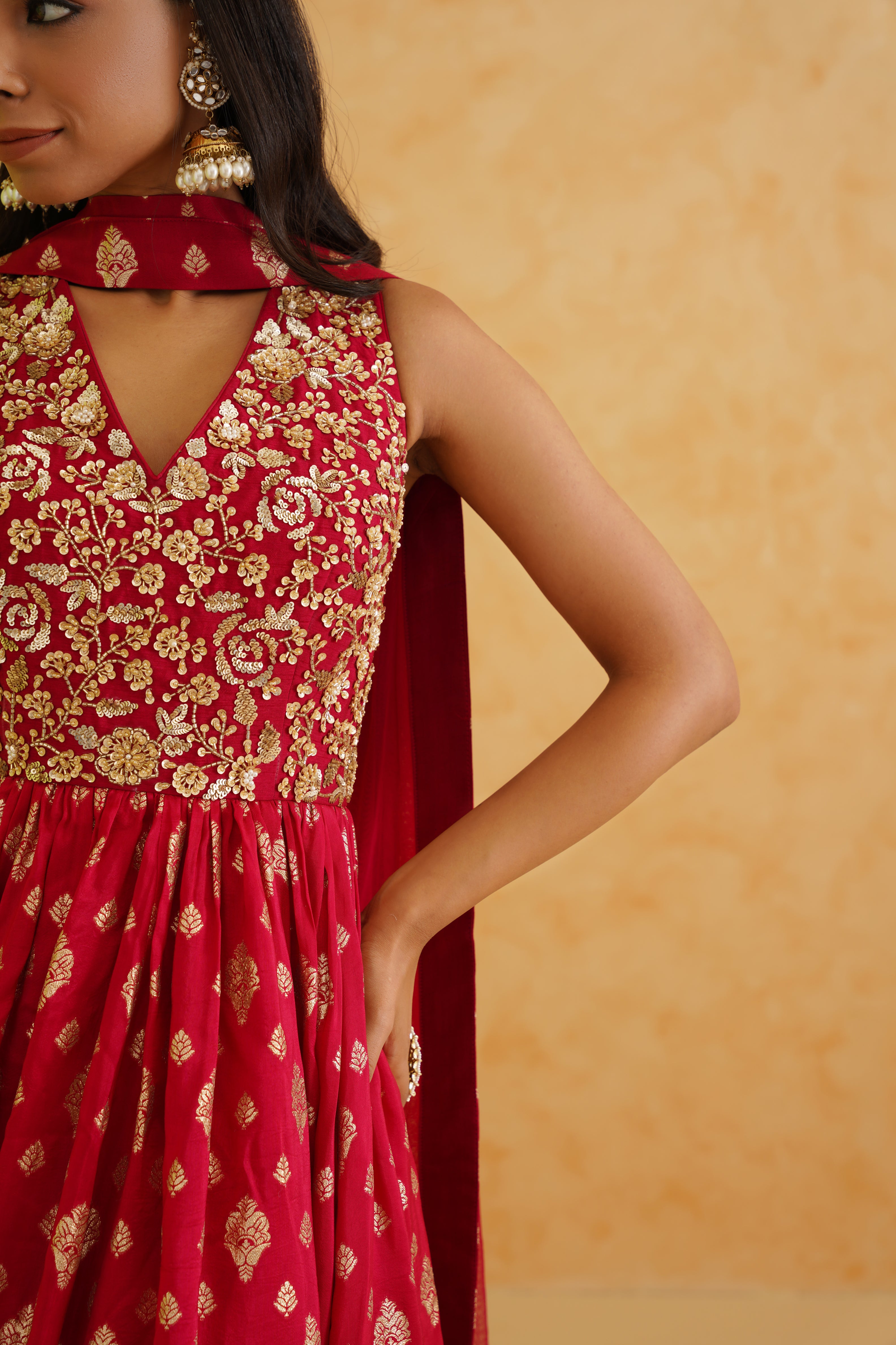 A captivating red anarkali outfit with a touch of glamour, featuring intricate brocade detailing and a flowing dupatta.