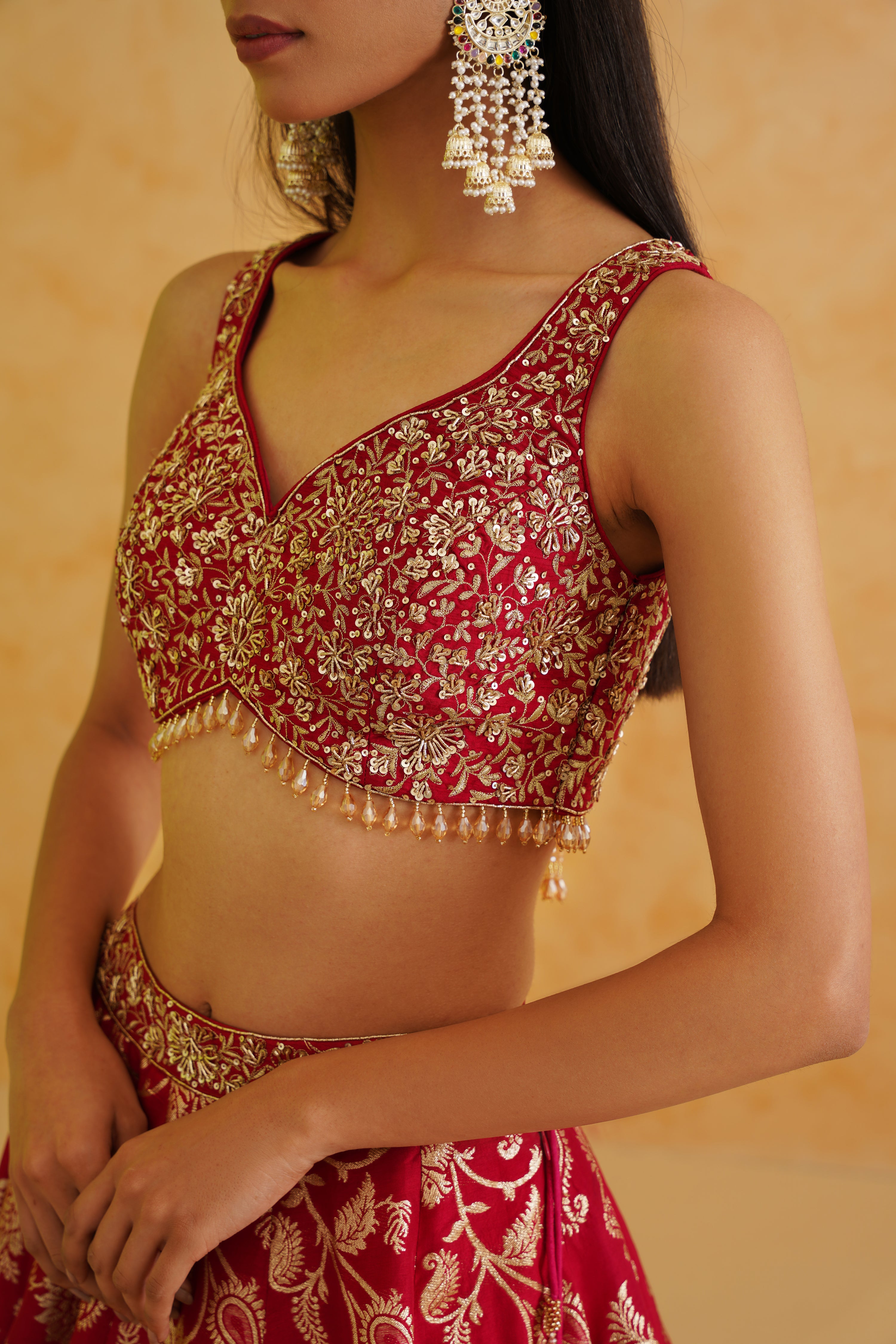 A sophisticated fuchsia brocade lehenga with delicate gold embellishments, offering a timeless and elegant look.