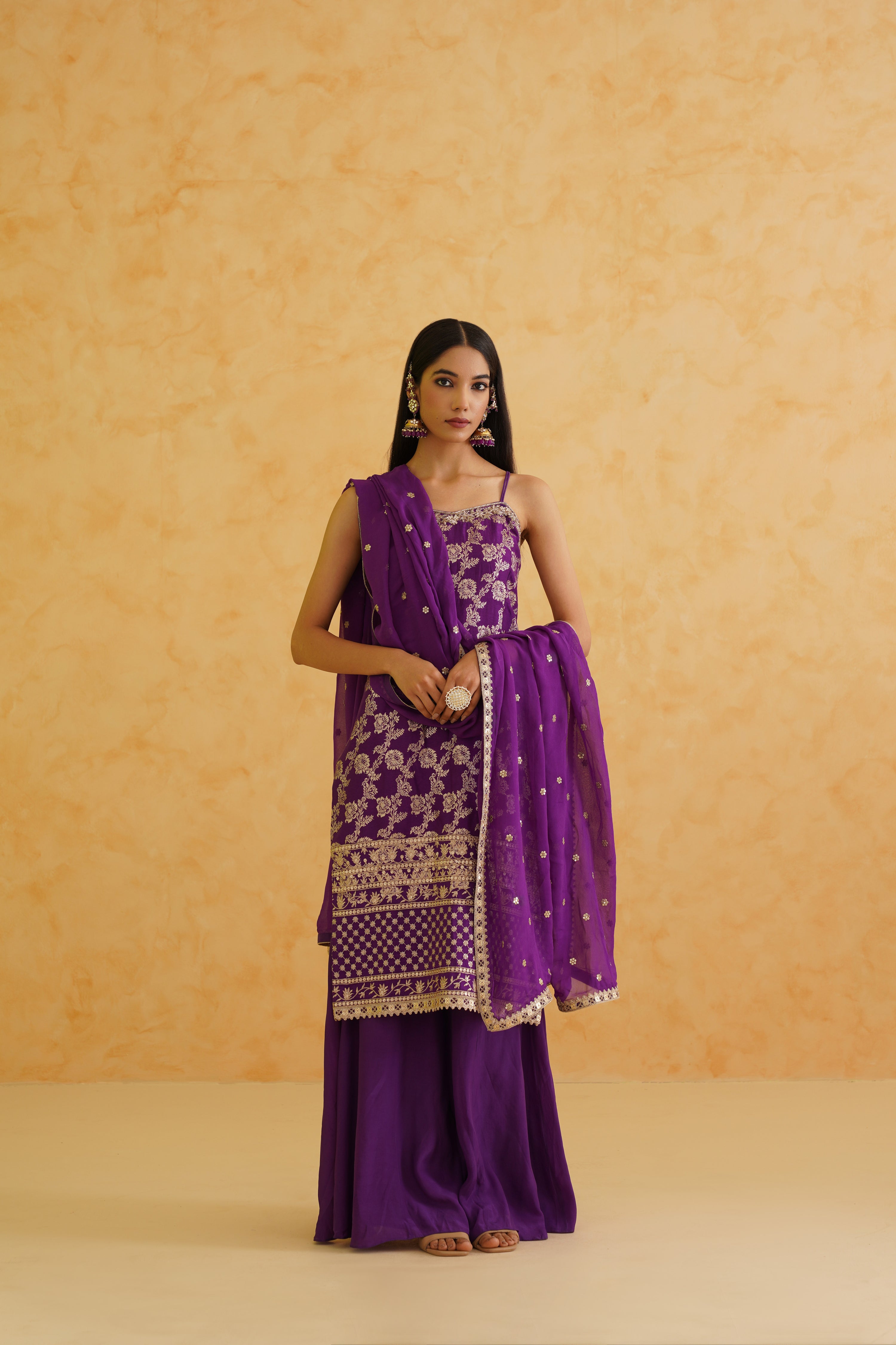 Elegant purple brocade kurti with intricate crystal, stone, and sequins embroidery, paired with a flowy sharara for a glamorous look.