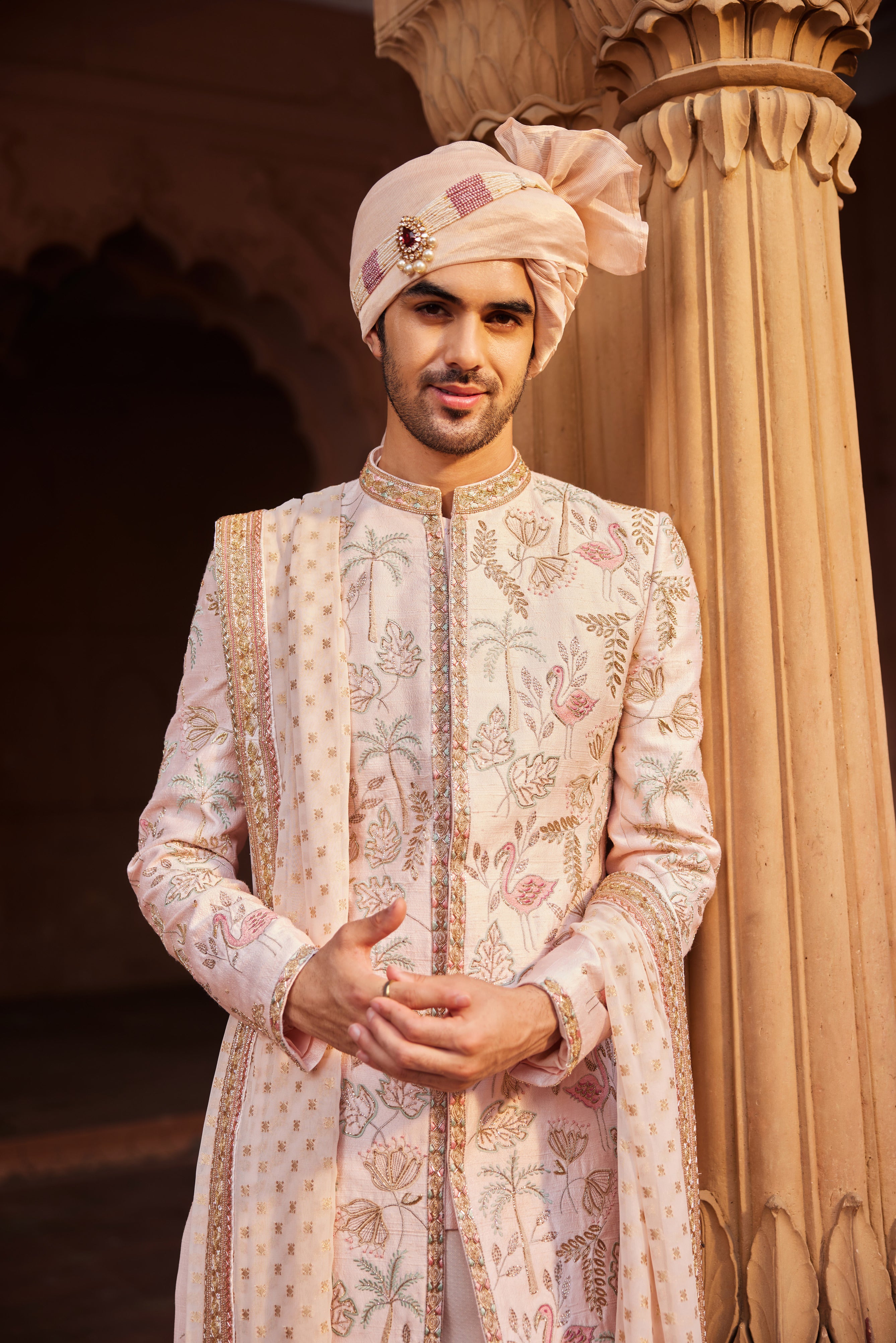 Close-up of sherwani featuring detailed resham, zari, zardozi, and dabka embroidery, highlighting the unique motifs. The look is complemented by an embroidered stole and traditional kurta pants.