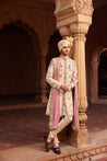 Close-up of a sherwani showcasing detailed hand embroidery with geometric and floral designs, complemented by a kurta, pants, and a matching embroidered stole.